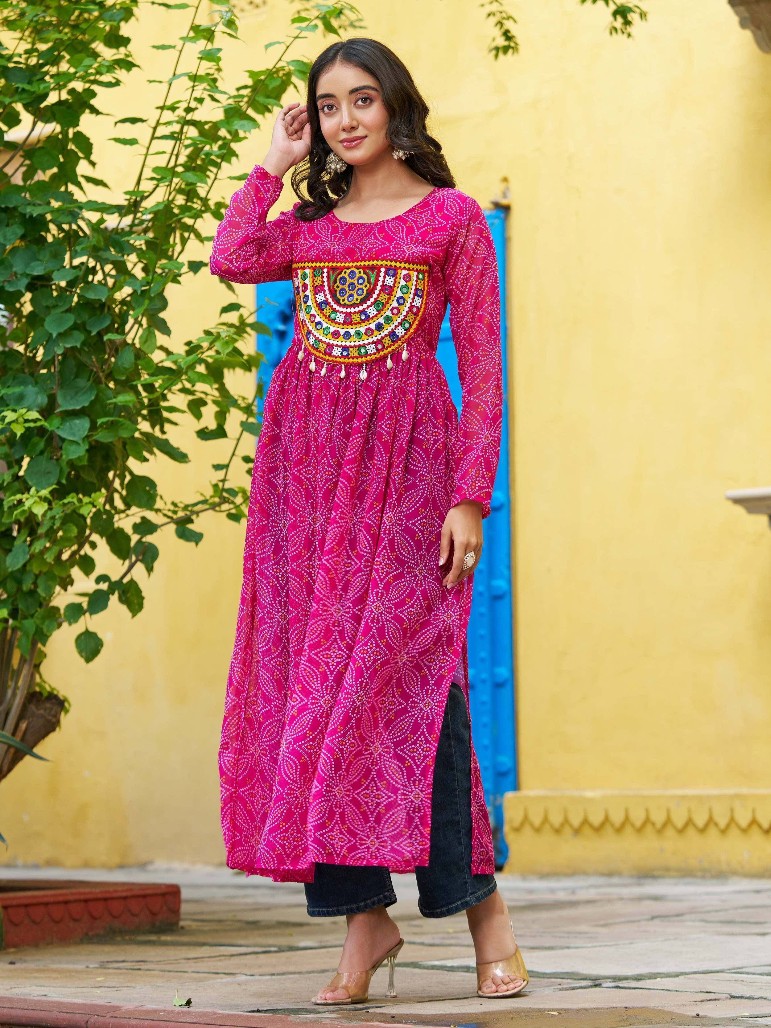 Pink embroidered ethnic kurti with mirror work, paired with jeans, perfect for Indian festive wear.