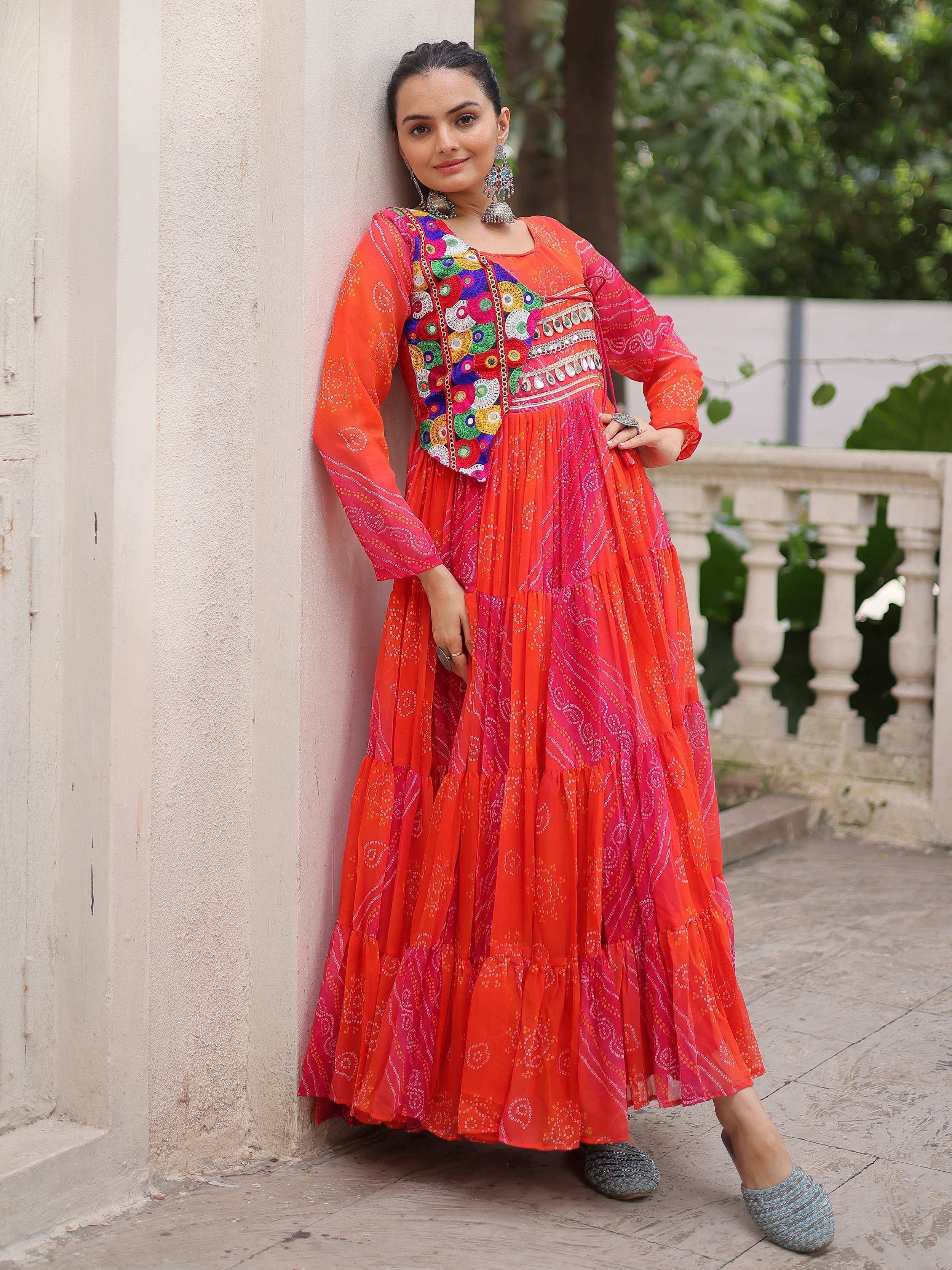 Vibrant orange and pink ethnic gown with mirror work, perfect for Indian festive occasions