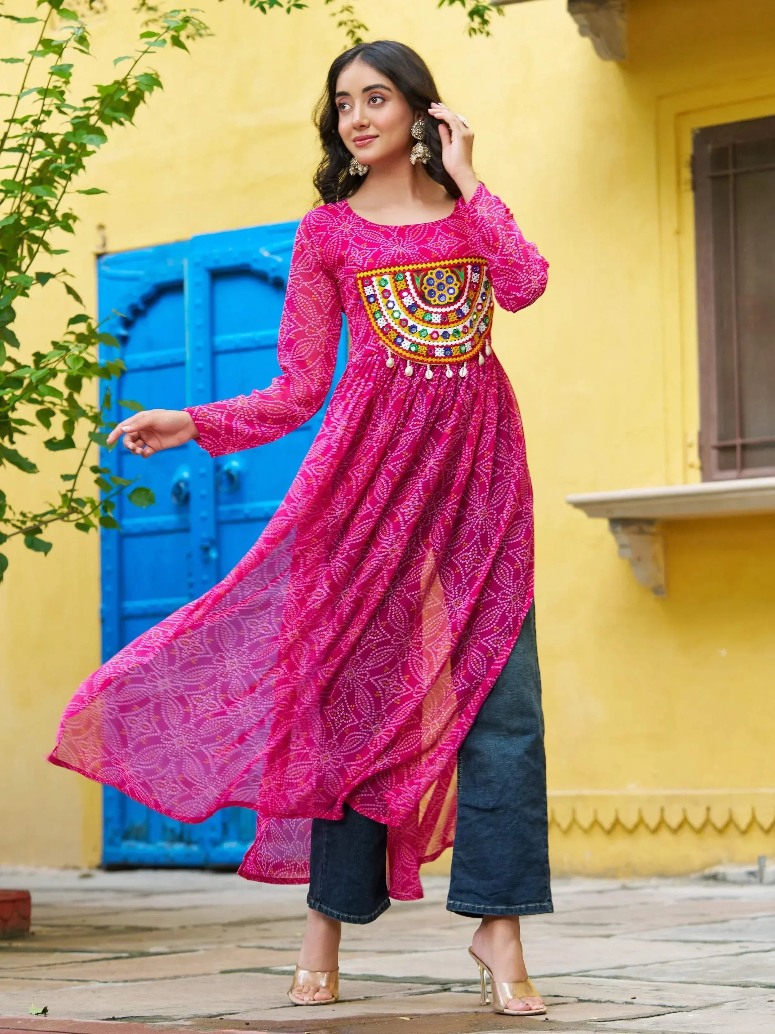 Pink embroidered ethnic kurta with mirror work, paired with denim pants, perfect for Indian festive wear.