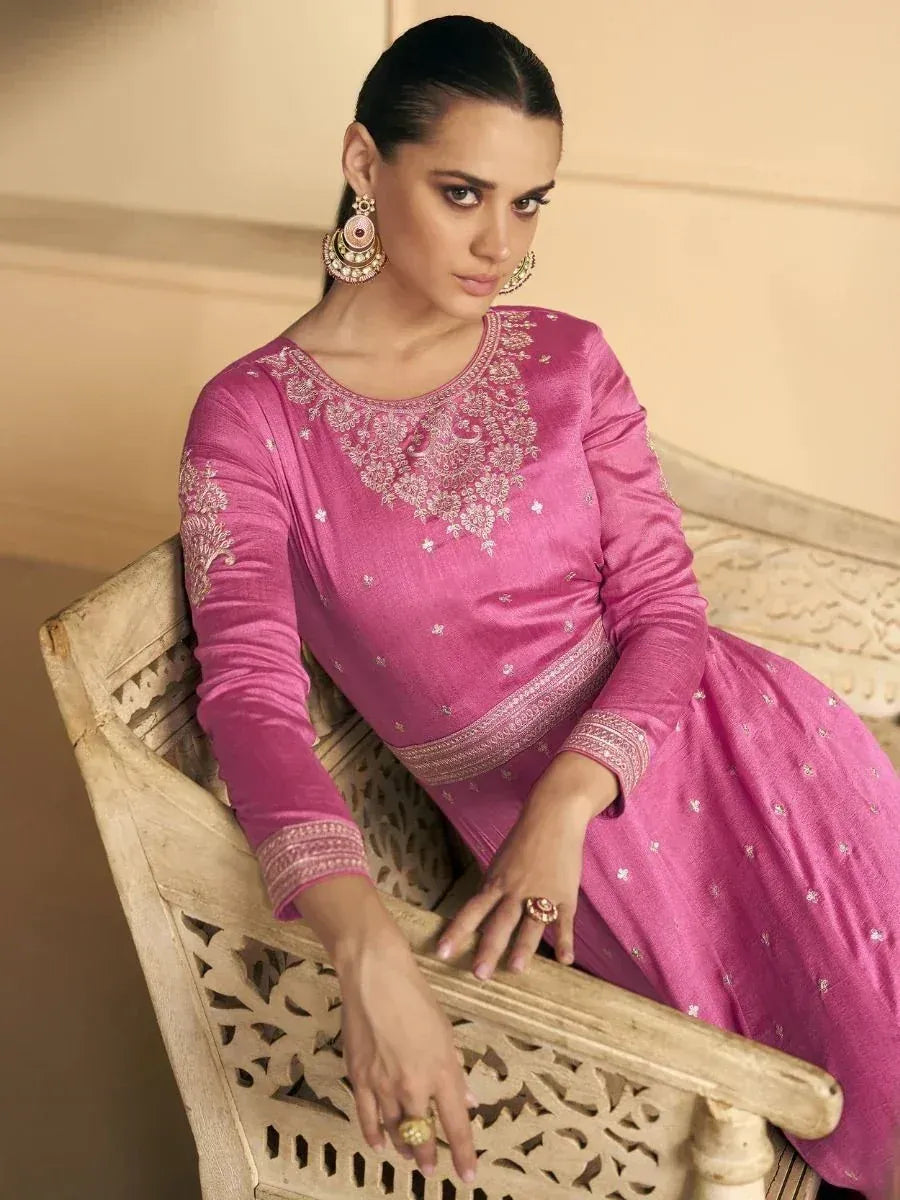 Pink embroidered ethnic gown with intricate neckline, paired with statement earrings, perfect for Indian occasions