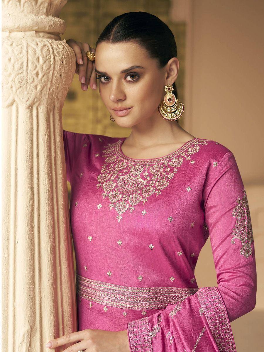 Pink embroidered ethnic salwar kameez with gold detailing, styled with jhumka earrings for festive occasions