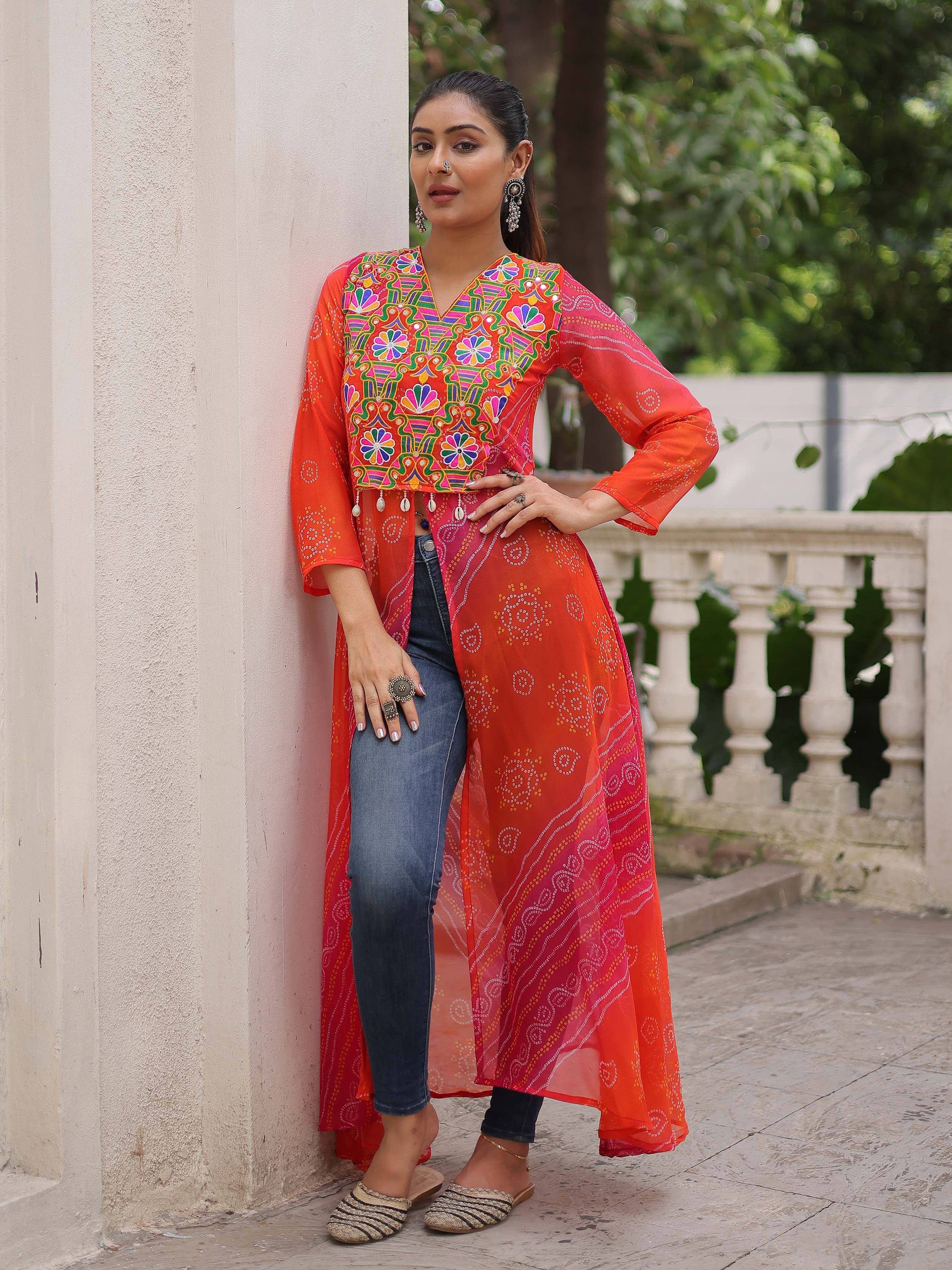 Vibrant orange embroidered kurta with mirror work, paired with jeans, perfect for Indian ethnic wear