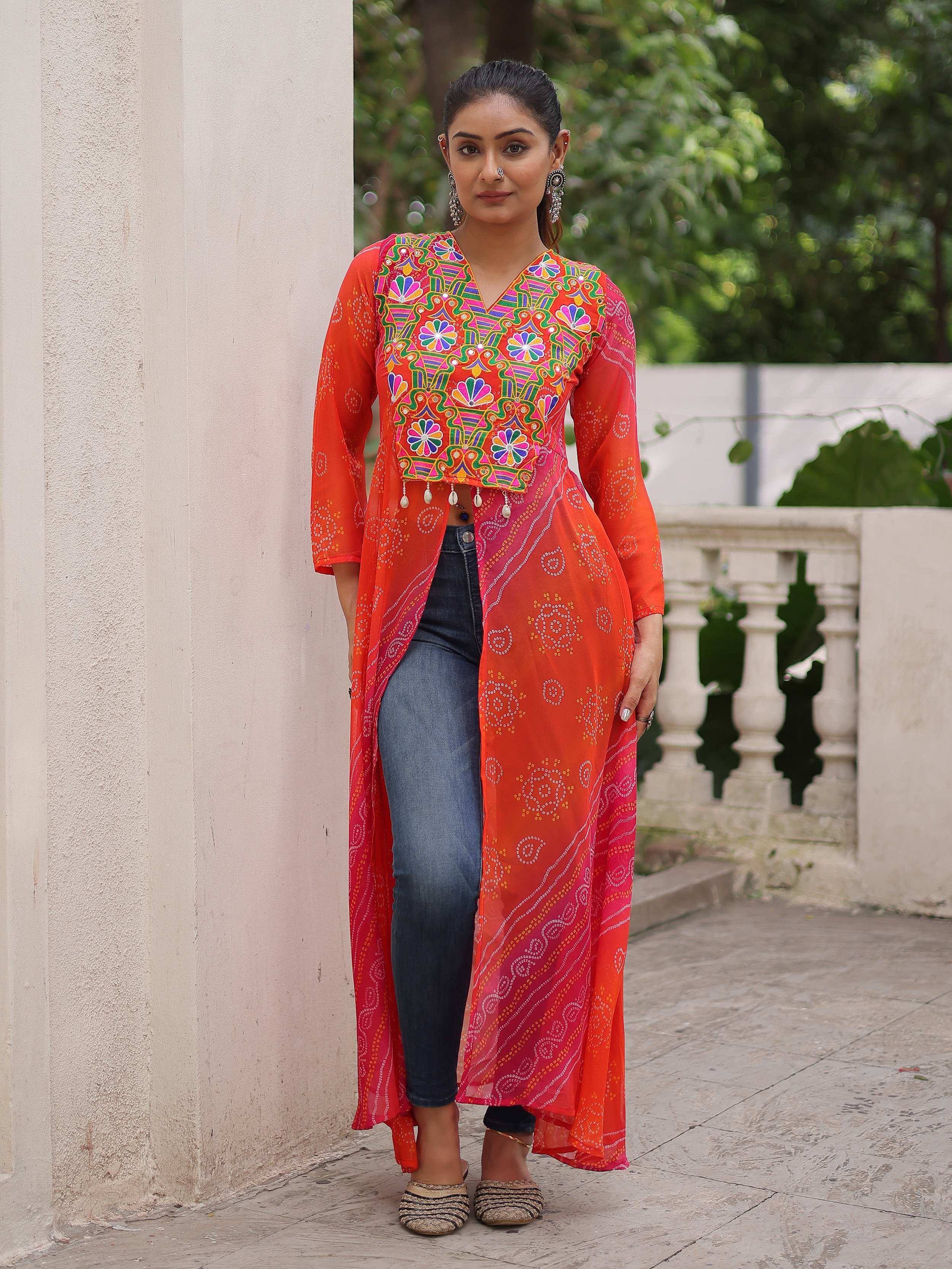 Vibrant orange embroidered ethnic kurti with bandhani print, paired with jeans for fusion wear