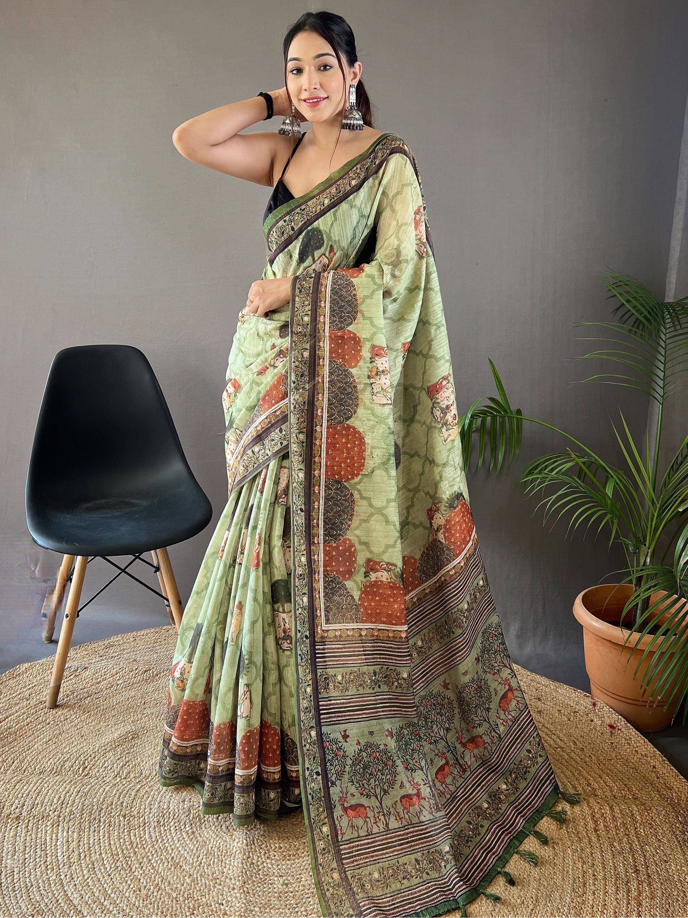 Woman in green printed saree with deer and floral motifs, ethnic Indian wear