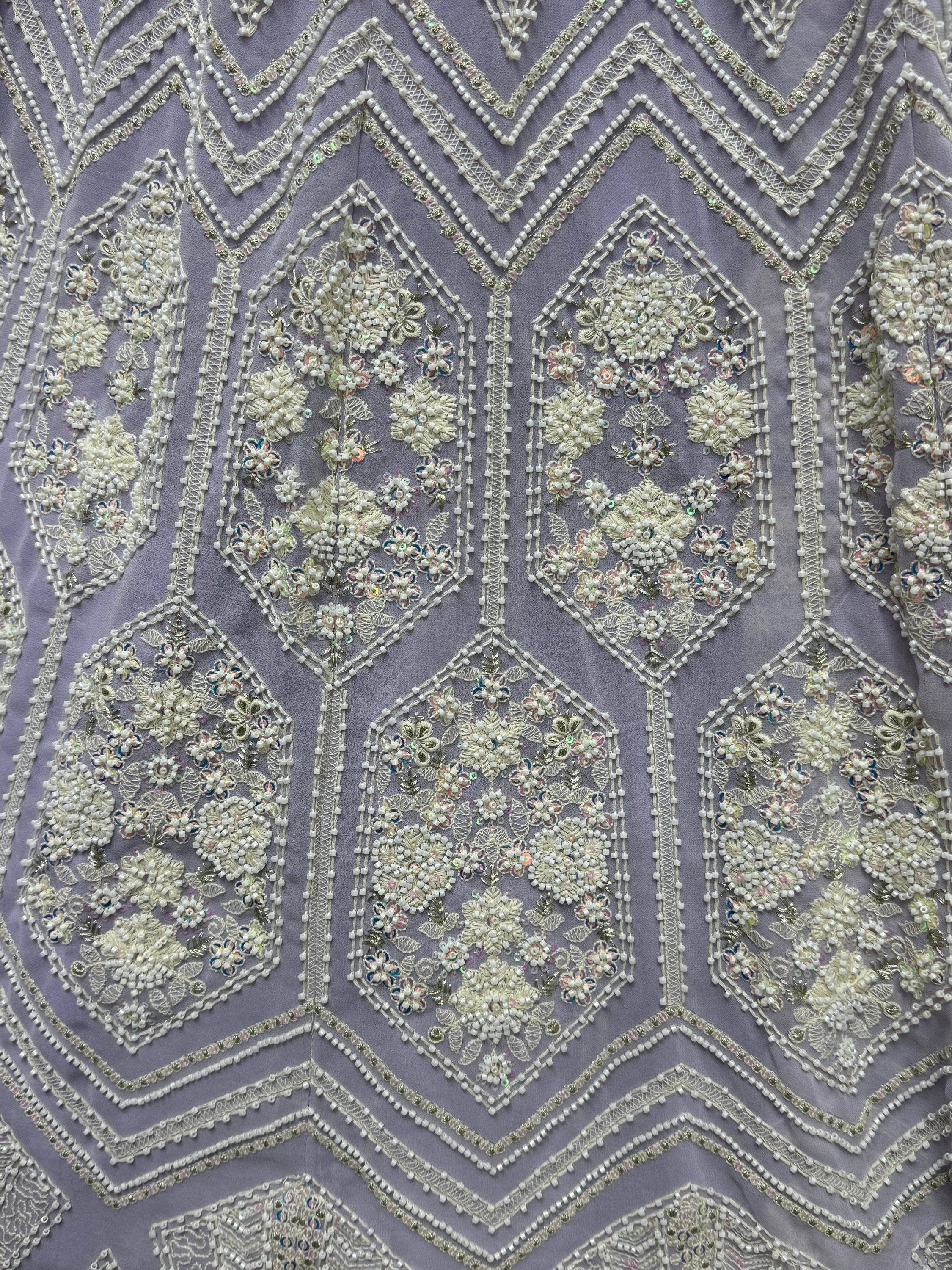 Lavender ethnic gown with intricate white beadwork, floral embroidery, and sequin detailing for festive occasions.