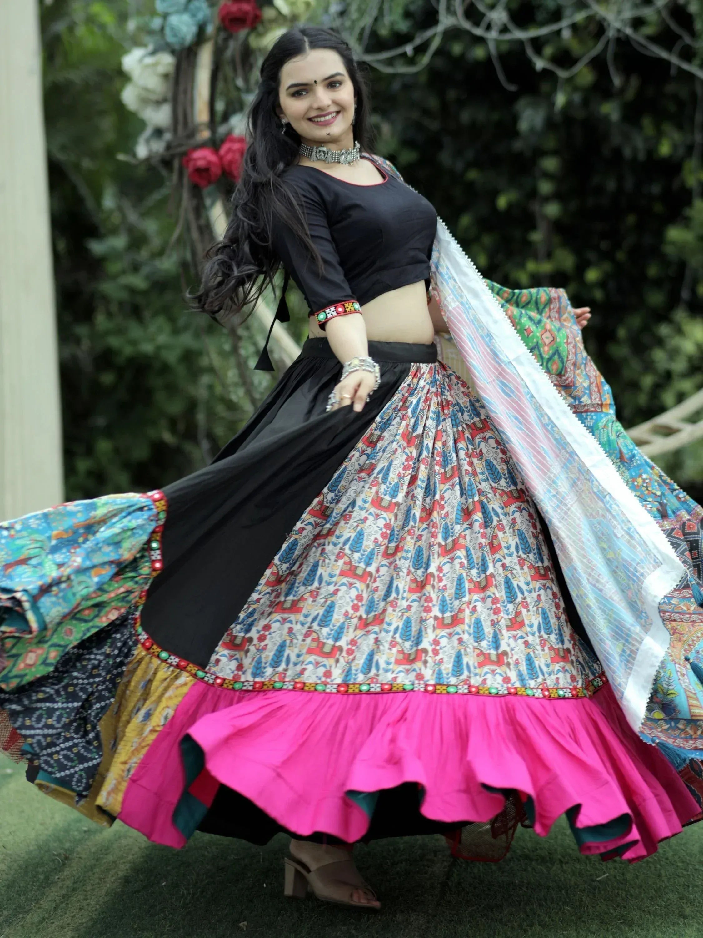Woman in vibrant Indian ethnic wear, black crop top with colorful printed skirt and dupatta, perfect for festive occasions