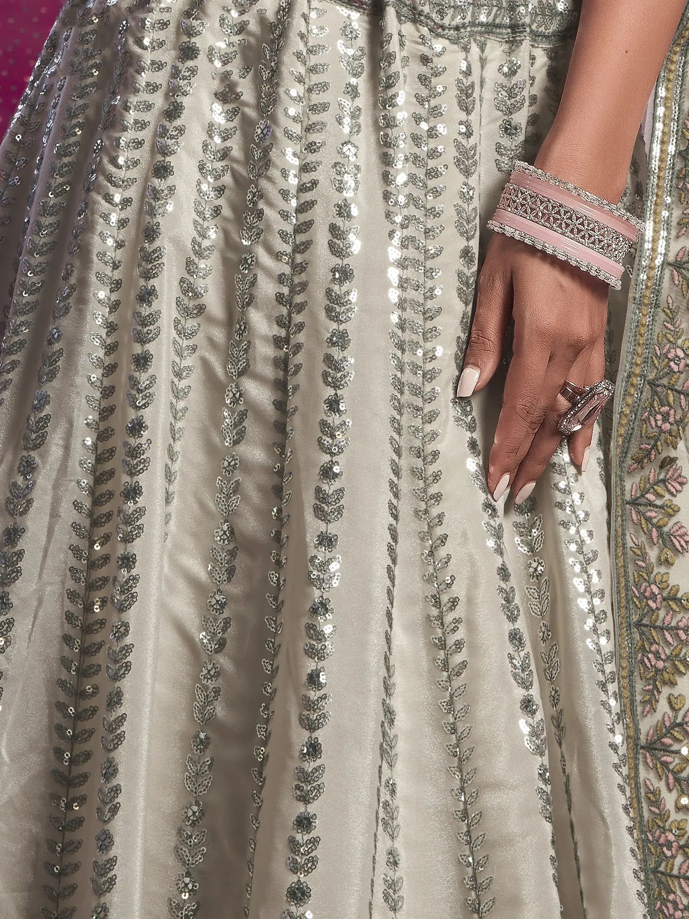 Elegant silver sequin lehenga with floral embroidery, paired with pink bangles and statement ring