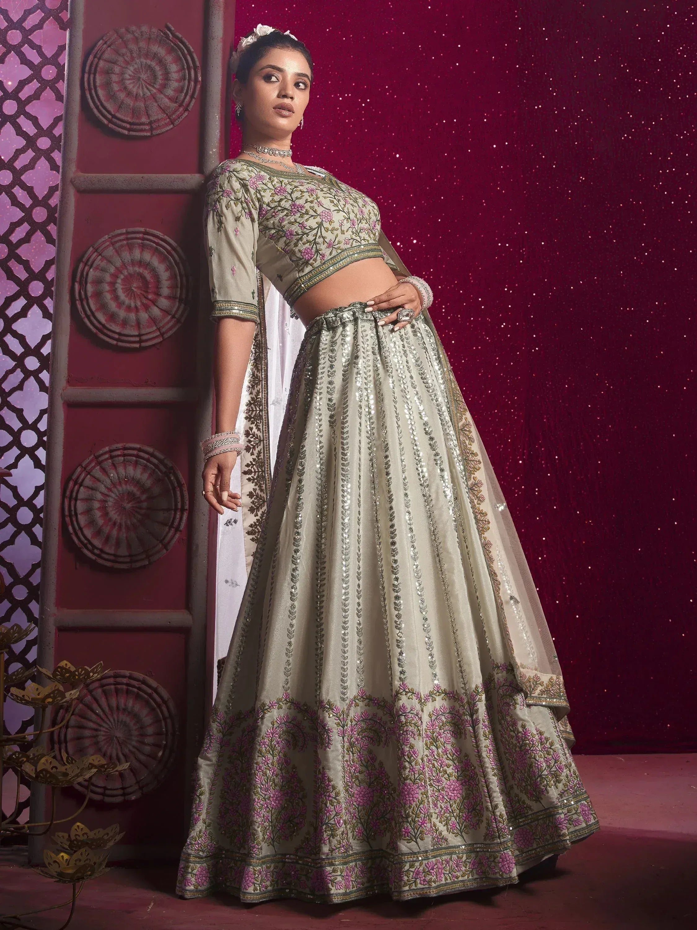 Elegant off-white lehenga choli with pink floral embroidery and sequin detailing, perfect for Indian weddings or festive occasions.
