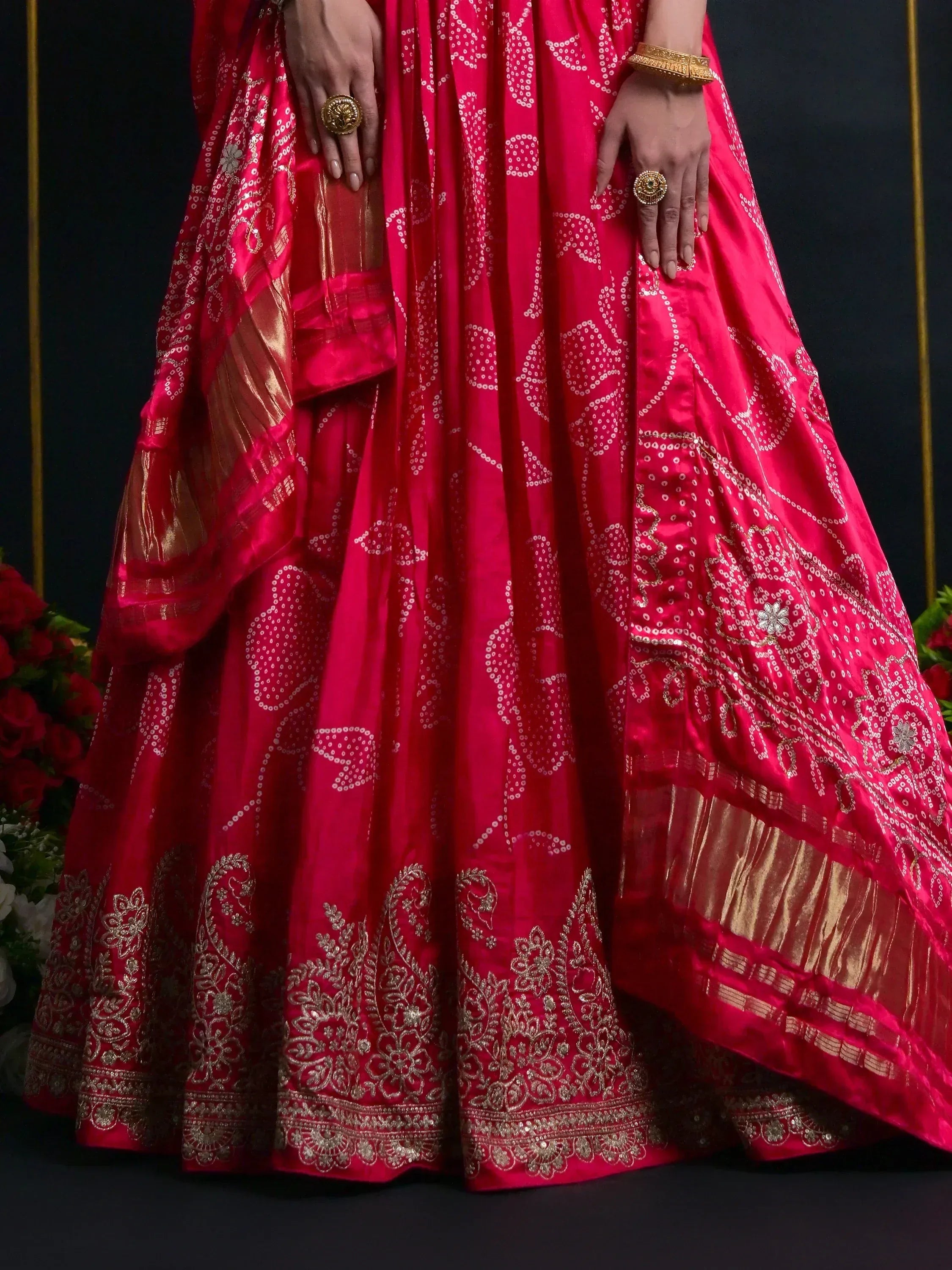 Red lehenga choli with gold embroidery and floral patterns, paired with traditional jewelry