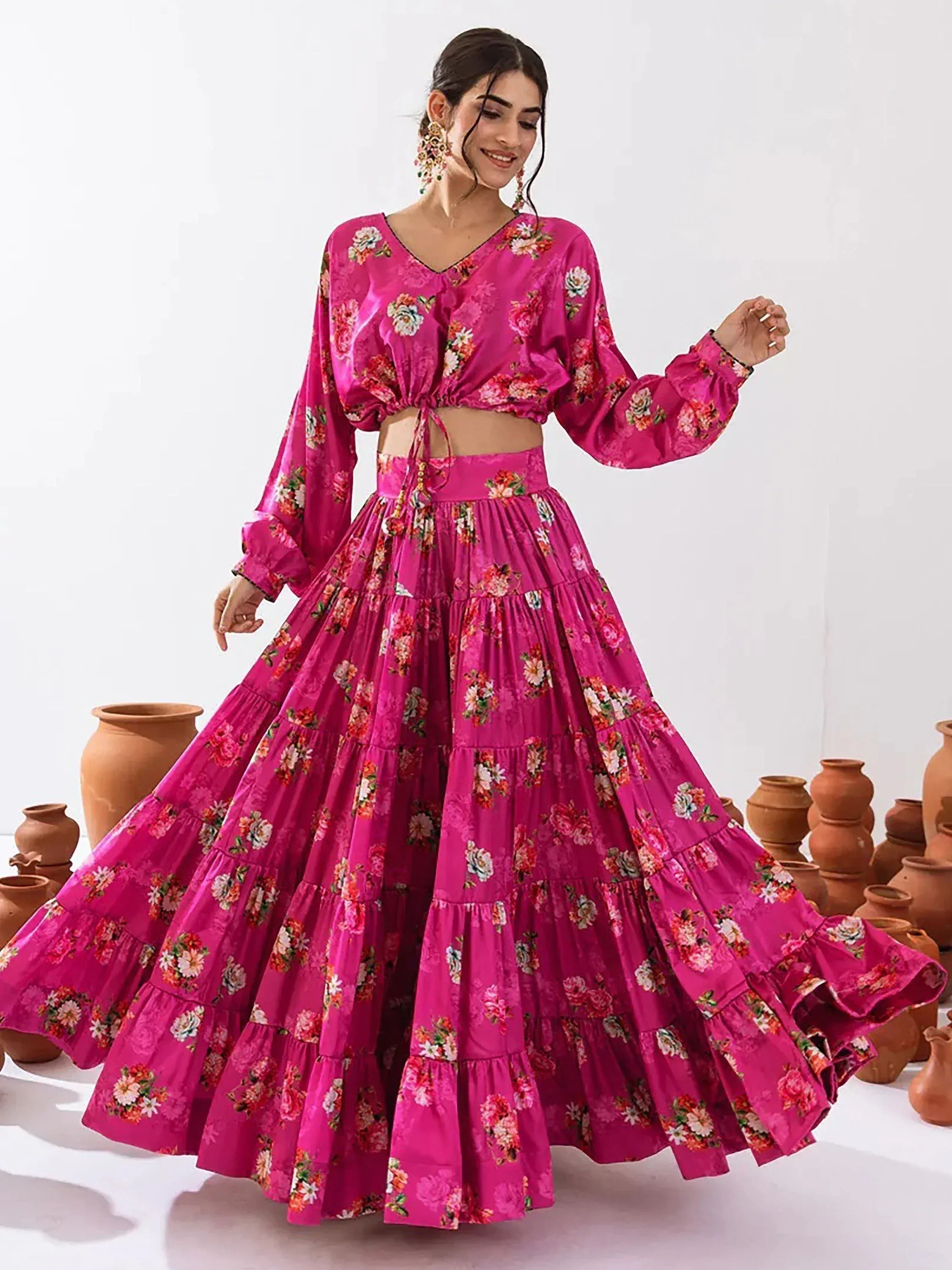 Vibrant pink floral lehenga choli with tiered skirt and long sleeves, perfect for ethnic occasions