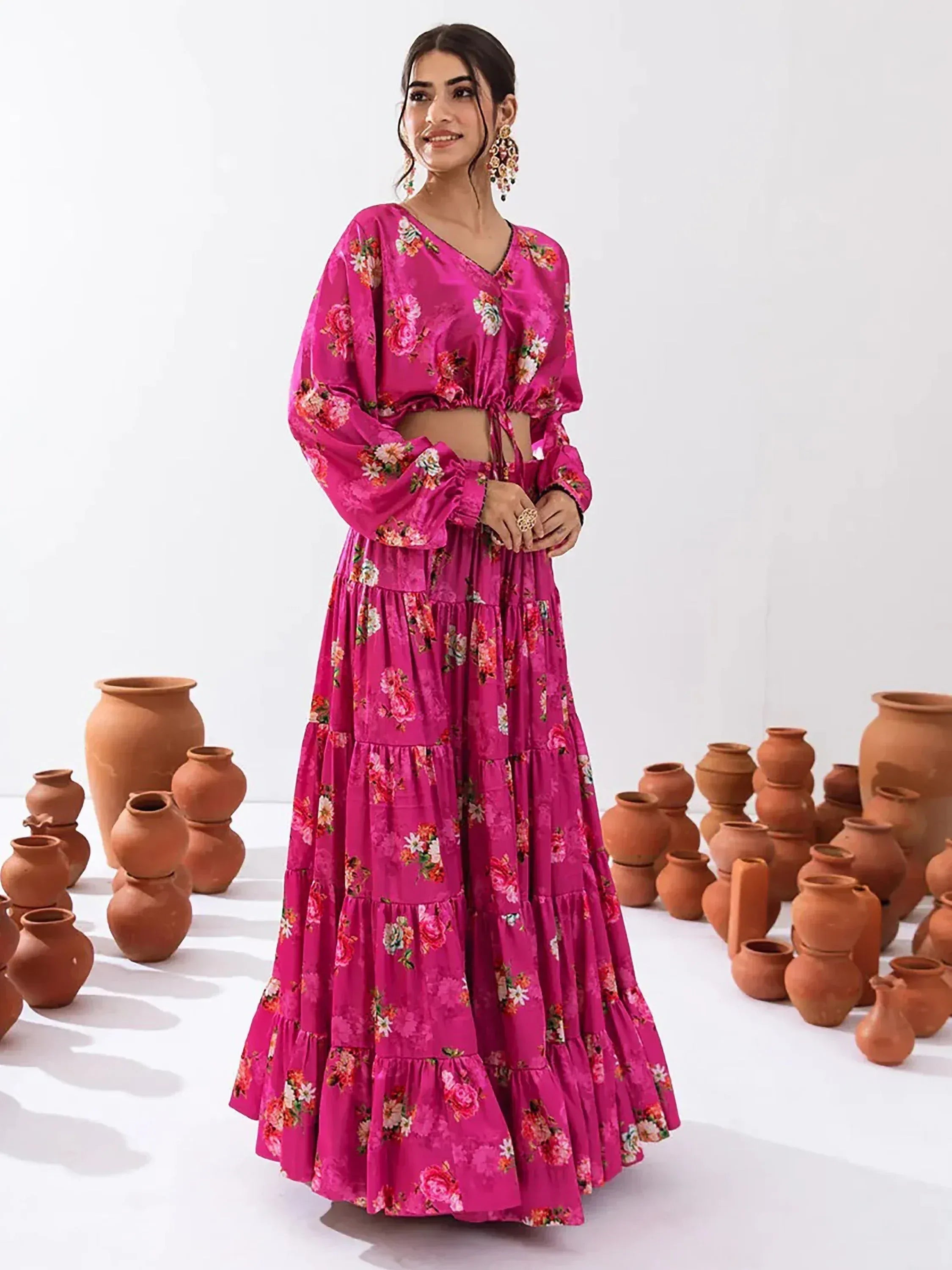 Pink floral ethnic gown with tiered skirt and puff sleeves, styled with clay pots