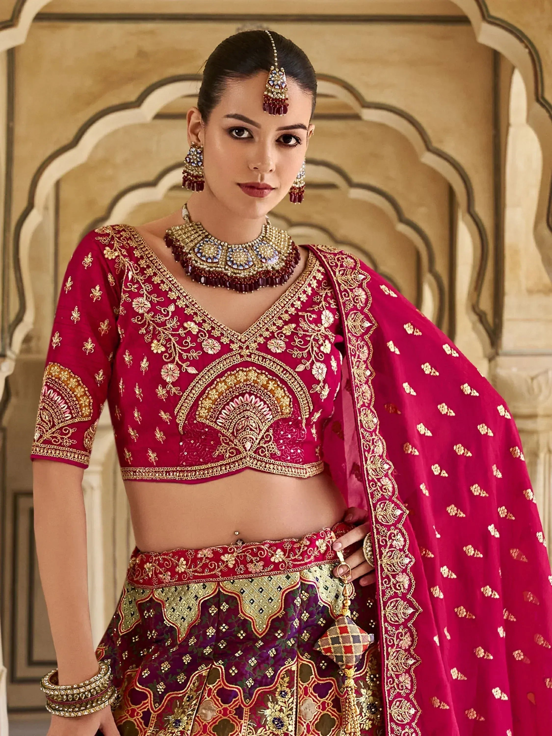Elegant maroon lehenga choli with gold embroidery, perfect for Indian weddings and festive occasions.