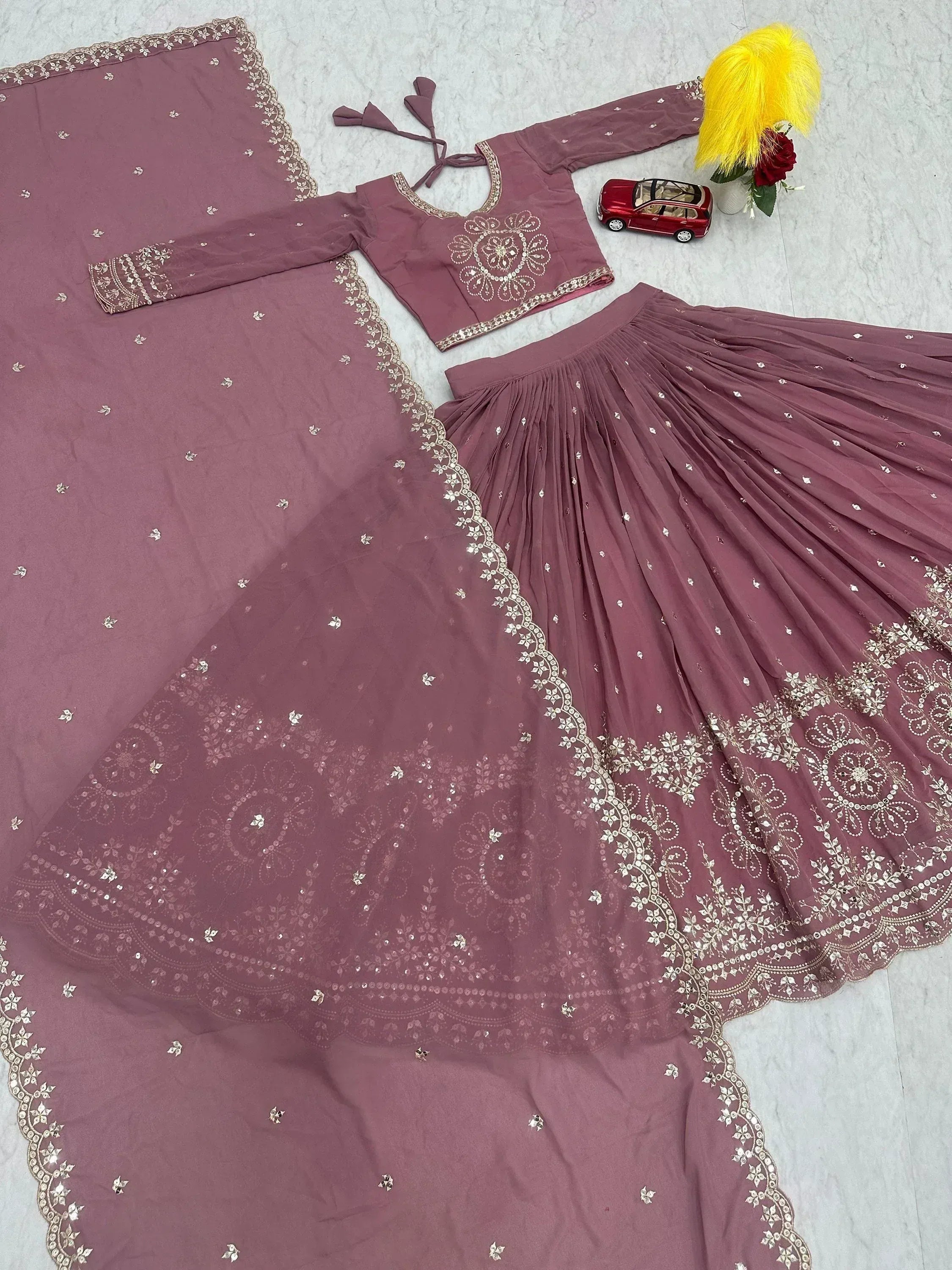 Dusty rose Indian ethnic lehenga choli with gold embroidery and mirror work, perfect for weddings and festivals.