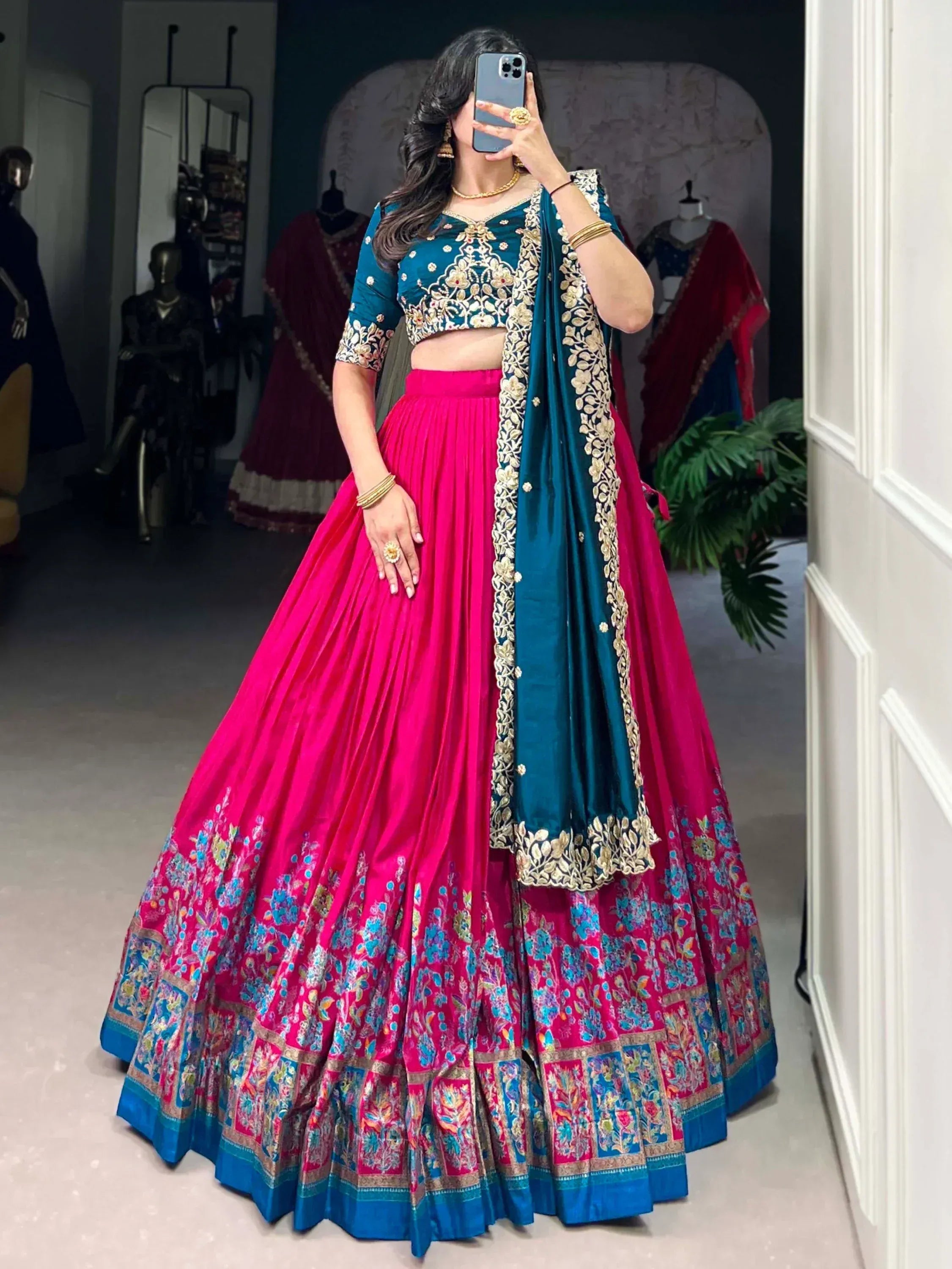 Pink and teal designer lehenga choli with gold embroidery, perfect for Indian weddings and festive occasions.