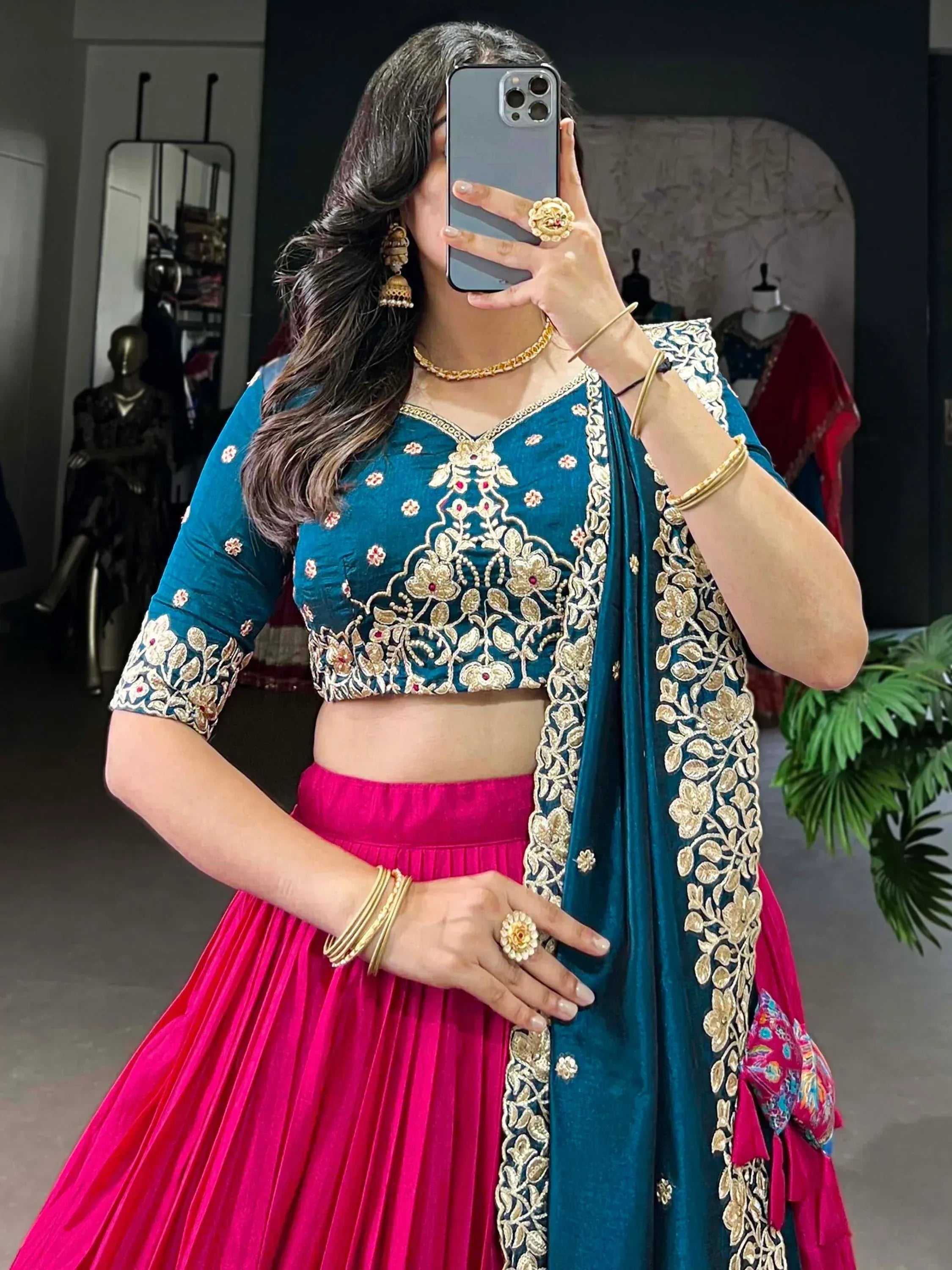 Teal and pink embroidered lehenga choli with gold floral detailing, perfect for Indian ethnic wear occasions.