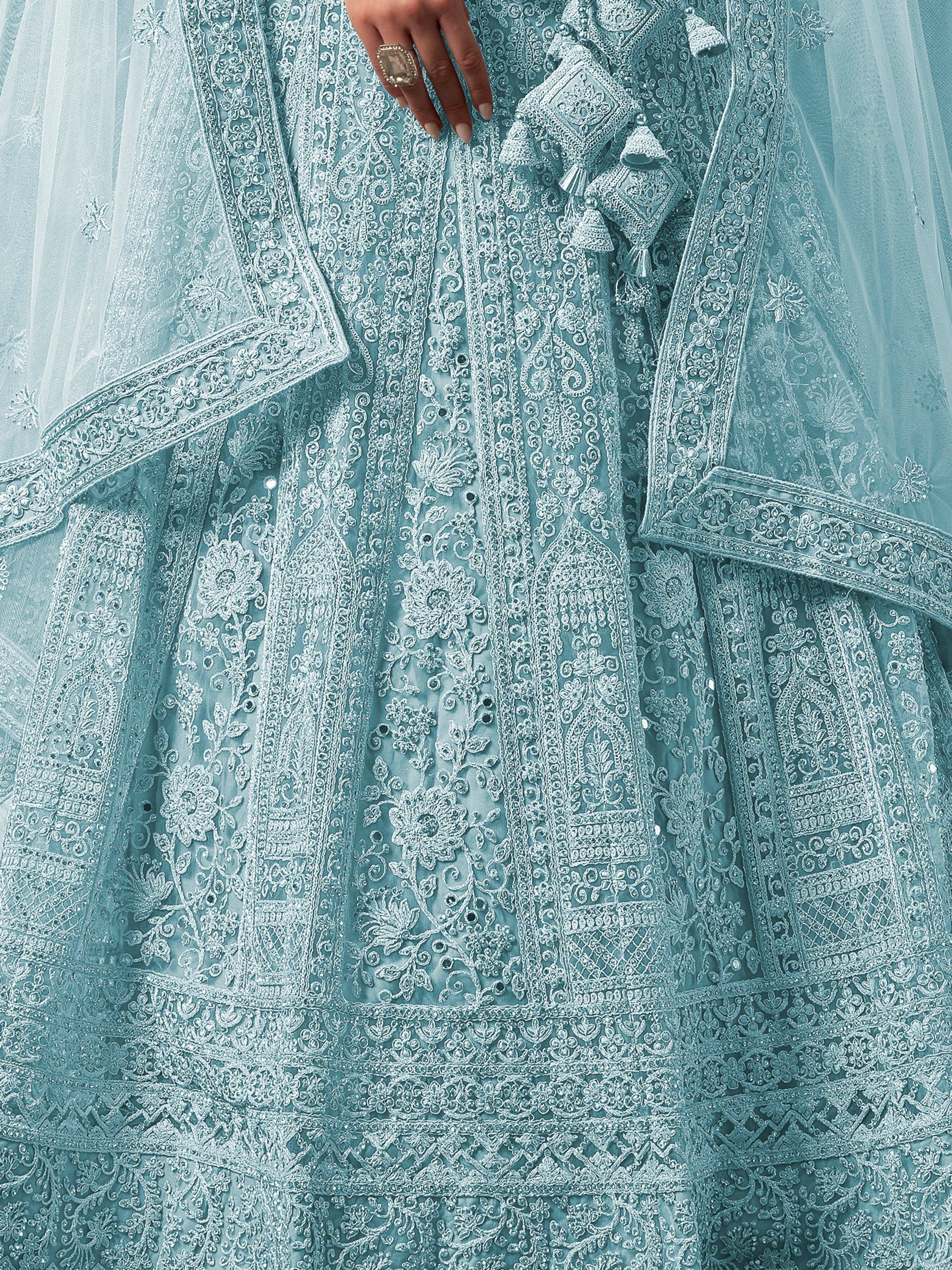 Light blue designer lehenga with intricate white embroidery and tassels, perfect for Indian ethnic wear.