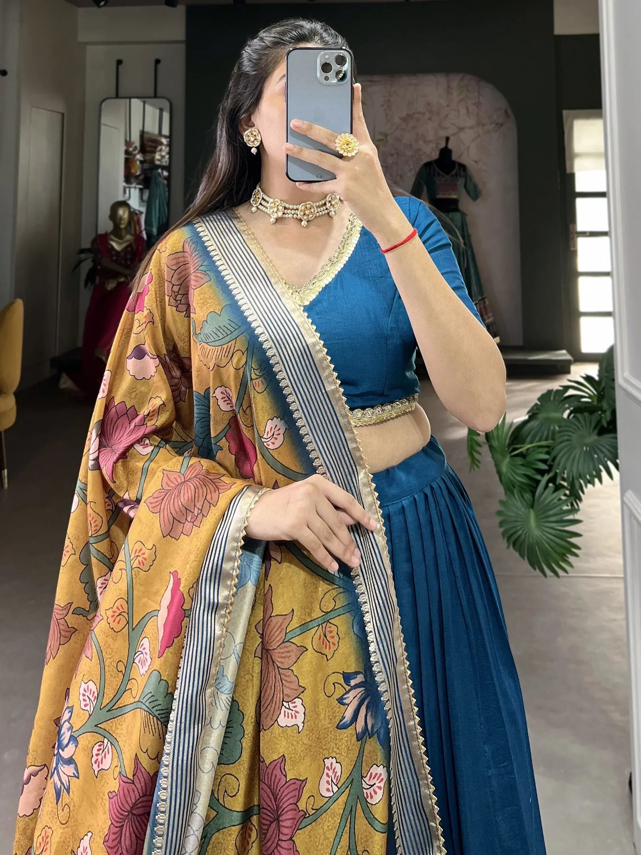 Woman in blue lehenga choli with floral dupatta, ethnic Indian wear for festive occasions