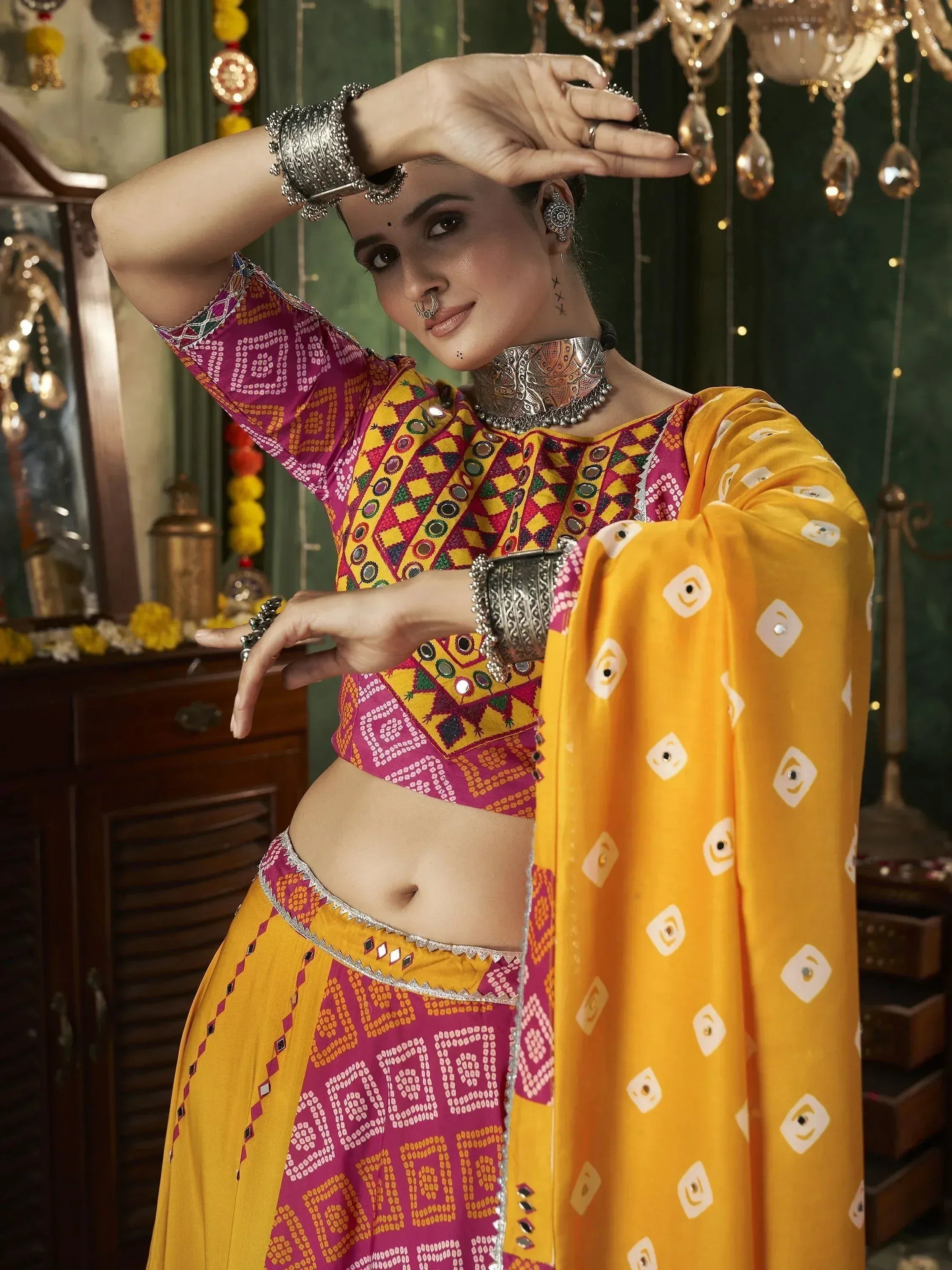 Vibrant yellow and pink ethnic lehenga choli with mirror work, perfect for Indian festivals and weddings.