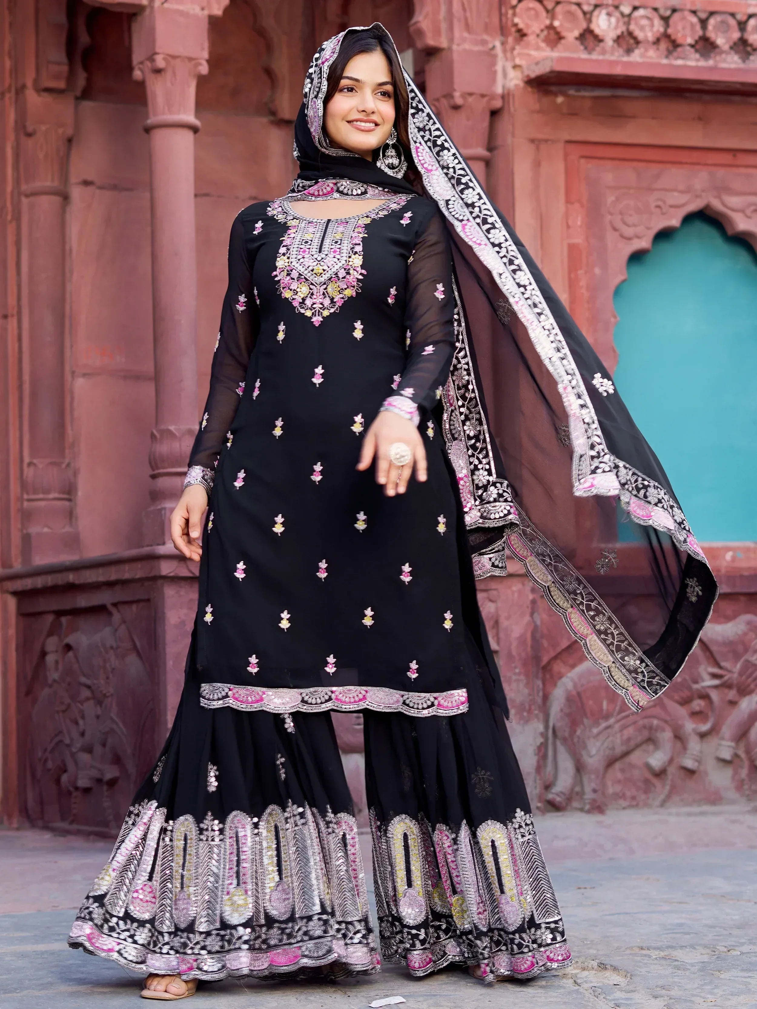 Black embroidered salwar kameez with pink and gold detailing, paired with matching dupatta