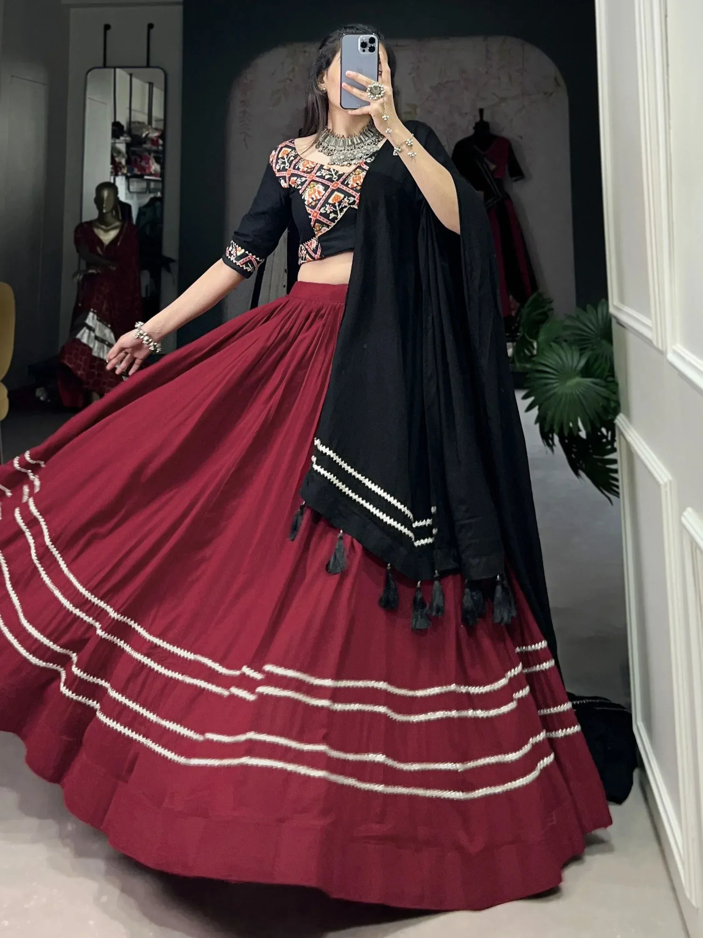 Woman in maroon lehenga with black embroidered choli and dupatta, showcasing Indian ethnic wear