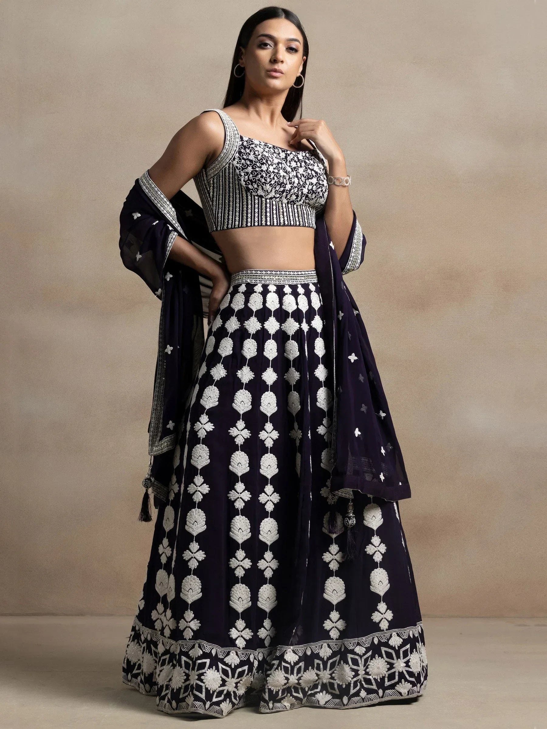 Navy blue embroidered lehenga choli with white floral motifs, perfect for Indian ethnic wear occasions.