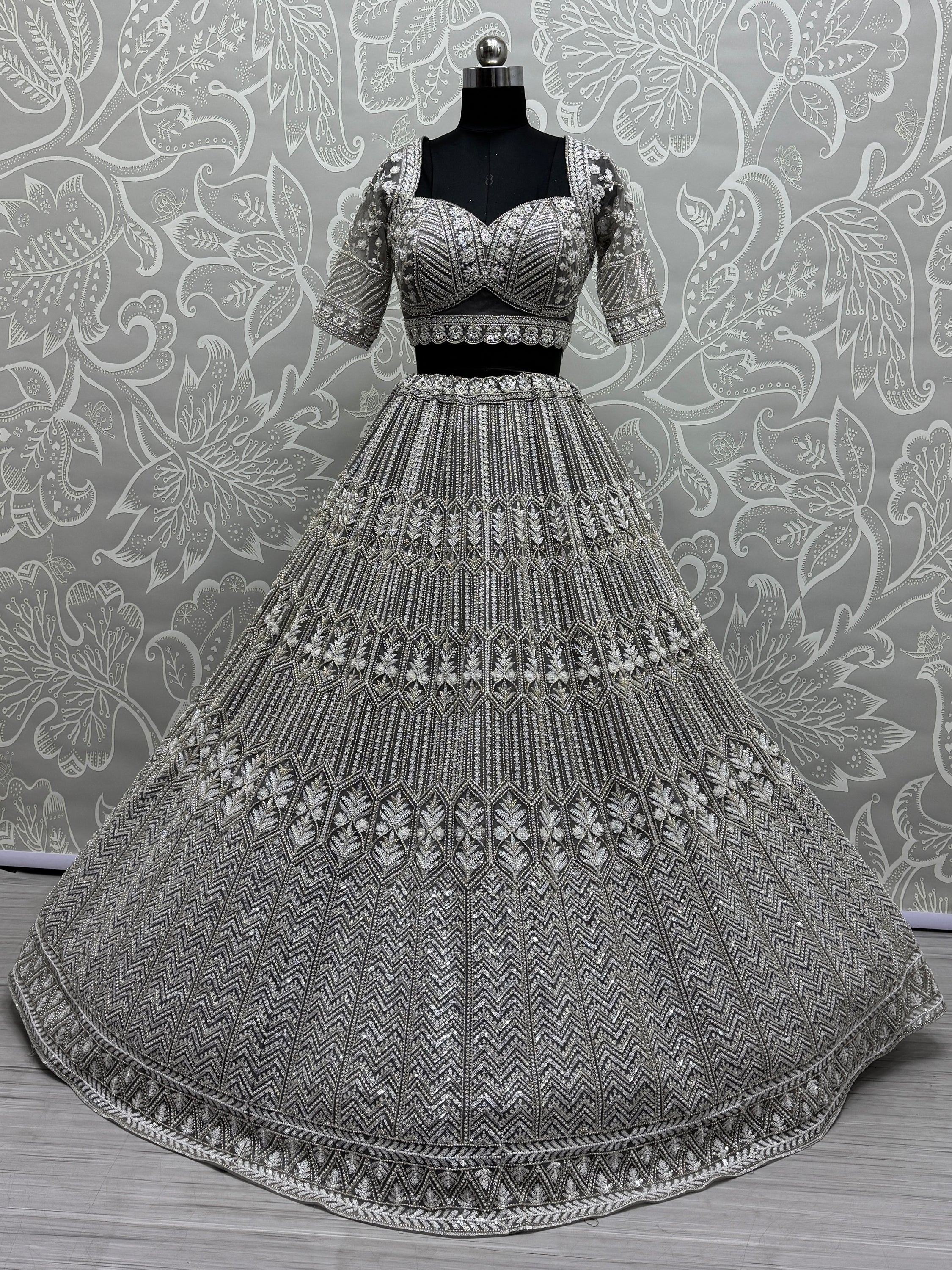 Elegant silver embroidered lehenga choli with intricate beadwork, perfect for Indian weddings and festive occasions.