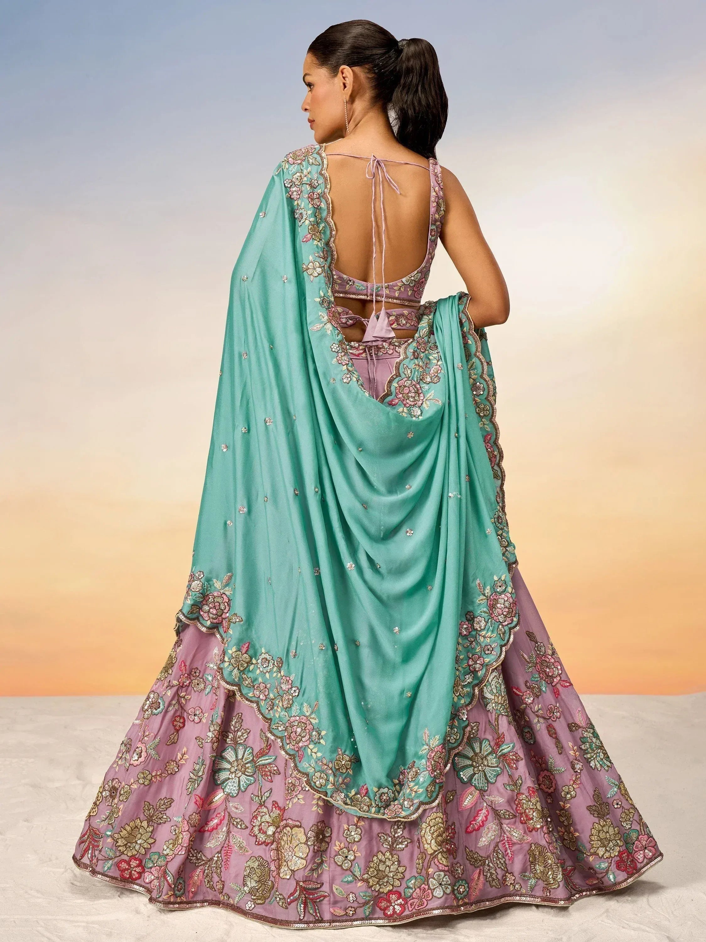 Elegant pink and mint green embroidered lehenga choli with floral detailing and open back design