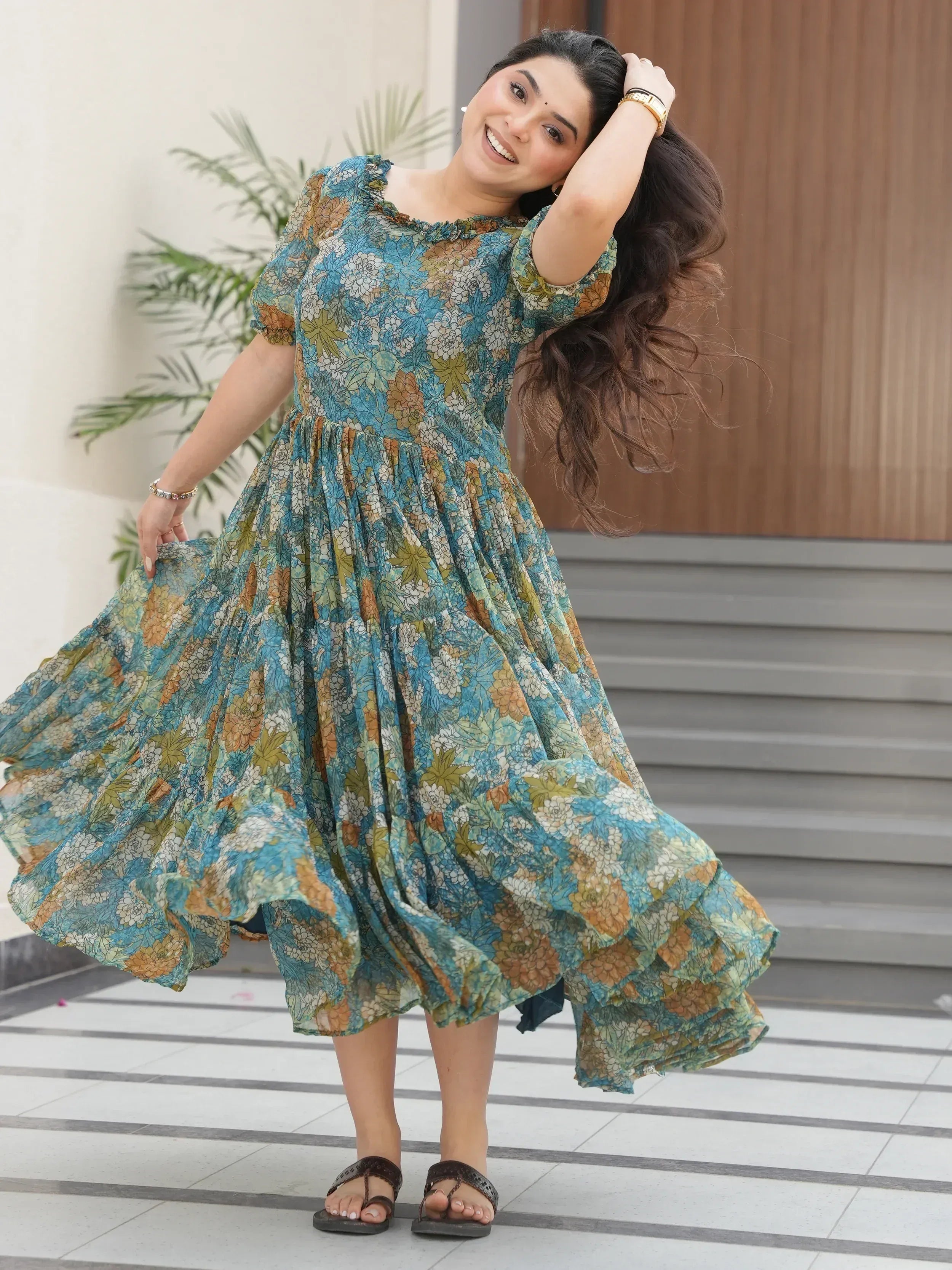 Woman in floral ethnic gown with puff sleeves, twirling outdoors