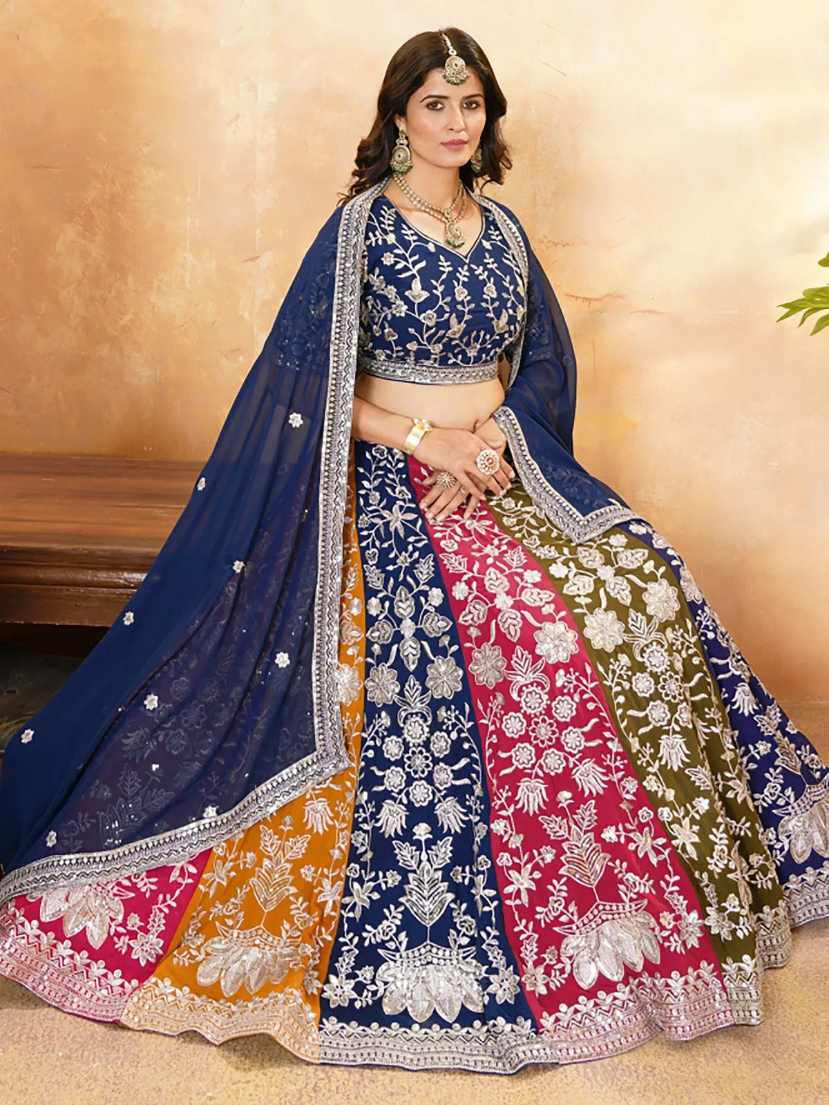 Blue, red, and green embroidered lehenga choli with floral zari work, perfect for Indian weddings and festive occasions.