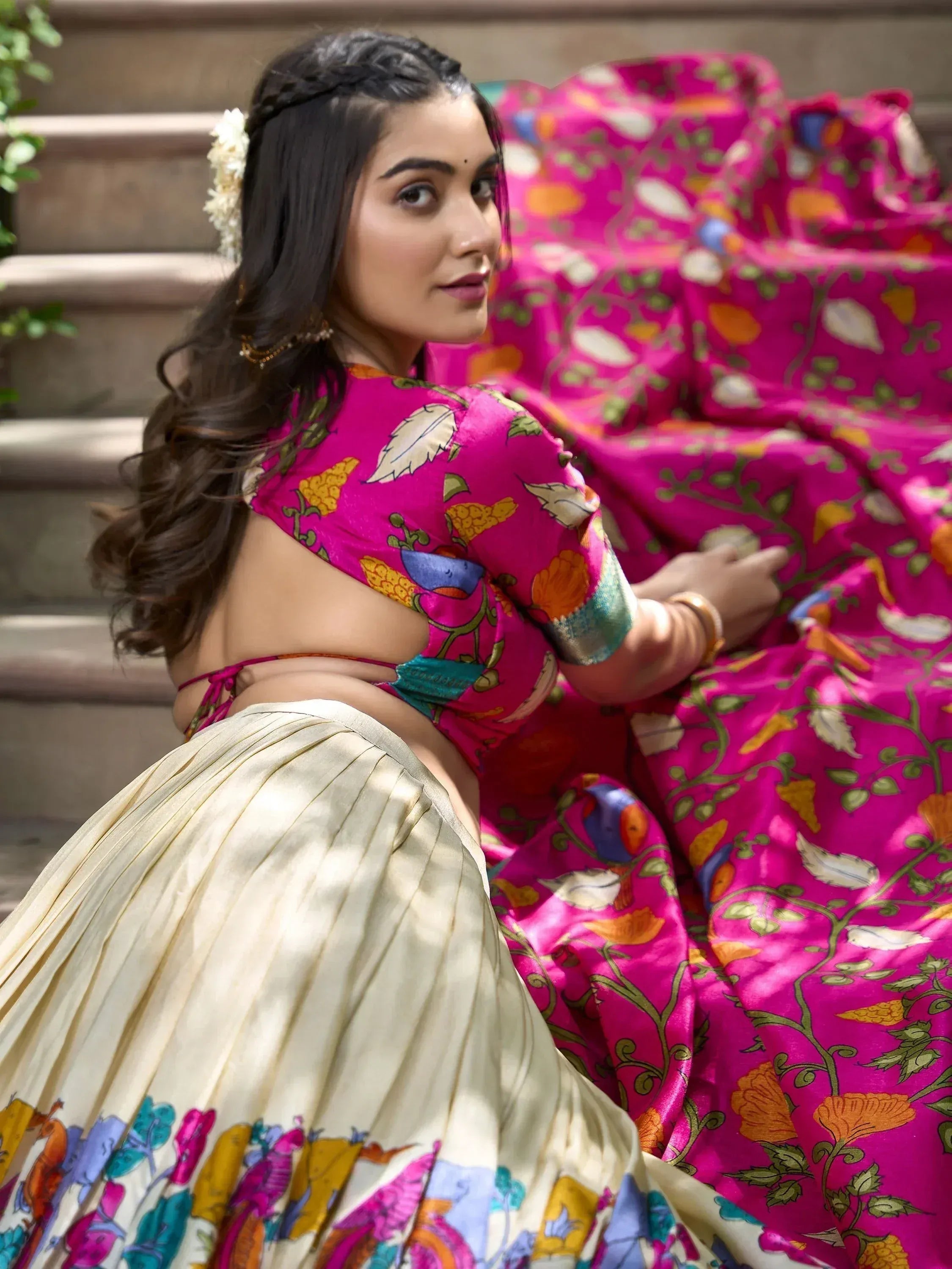 Woman in vibrant pink floral lehenga choli with pleated skirt, perfect for Indian ethnic wear occasions