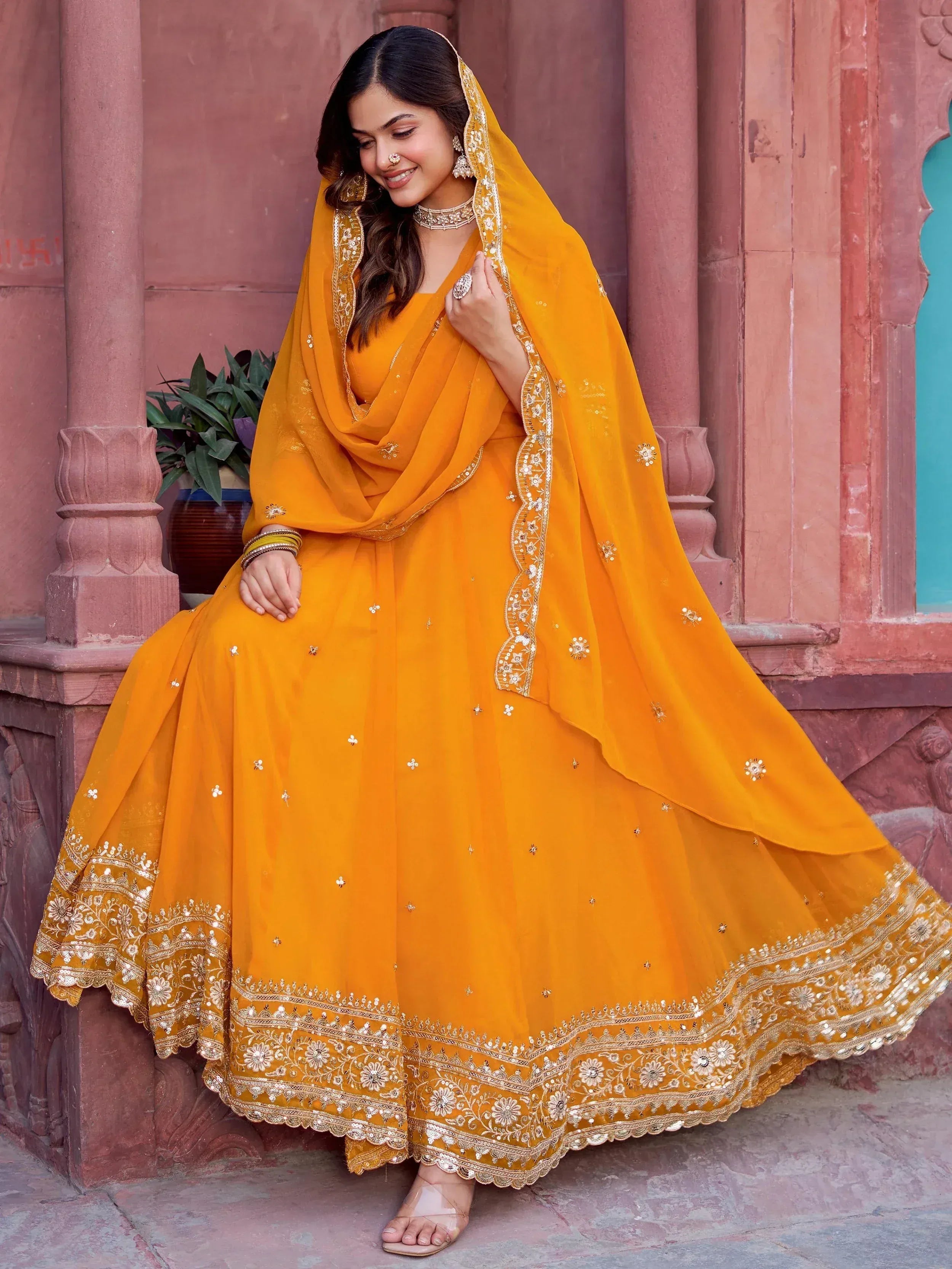 Woman in vibrant yellow designer lehenga choli with intricate gold embroidery, perfect for Indian ethnic wear occasions.