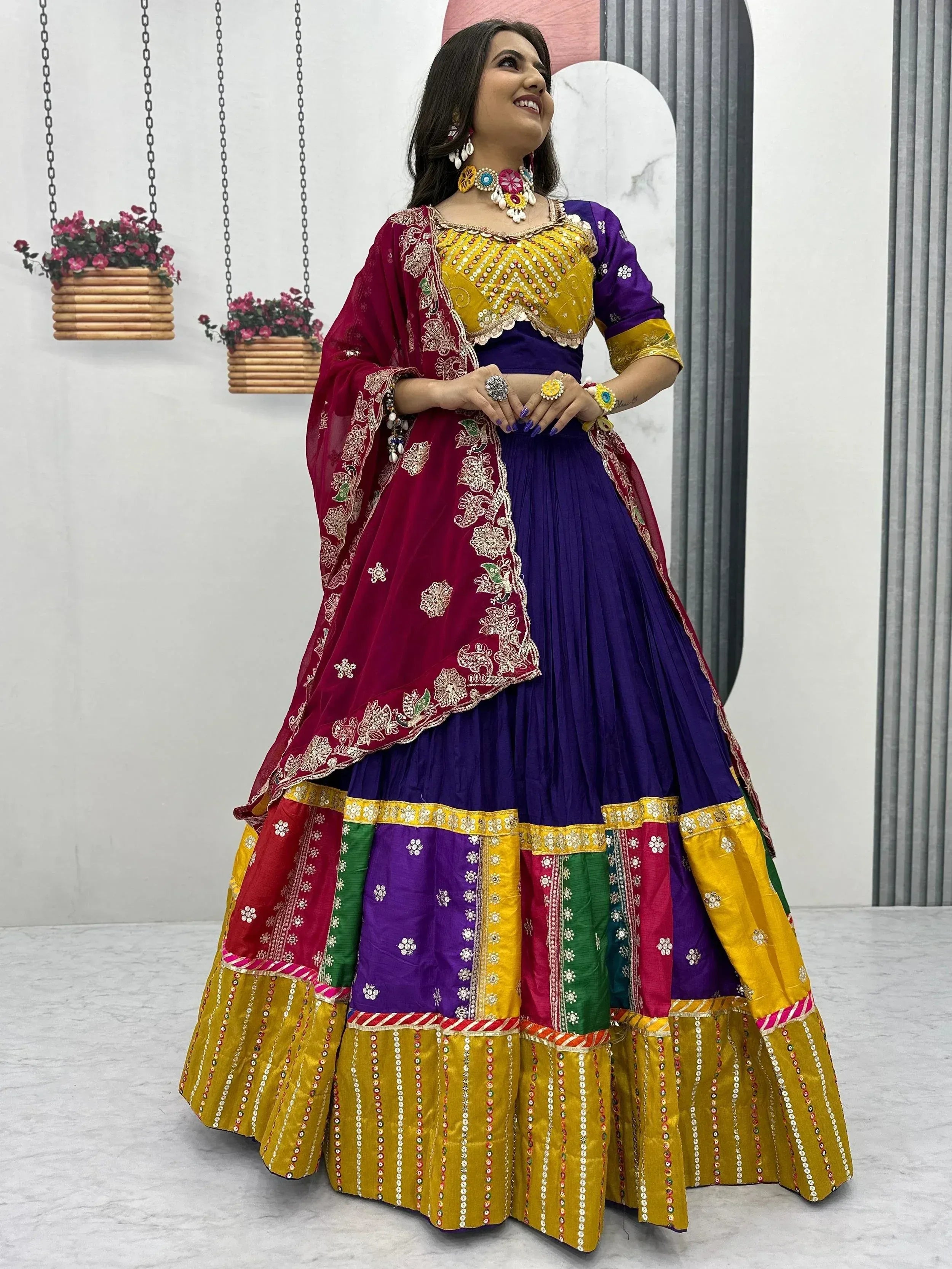 Vibrant purple and yellow Indian ethnic lehenga choli with mirror work, floral embroidery, and colorful dupatta for festive occasions