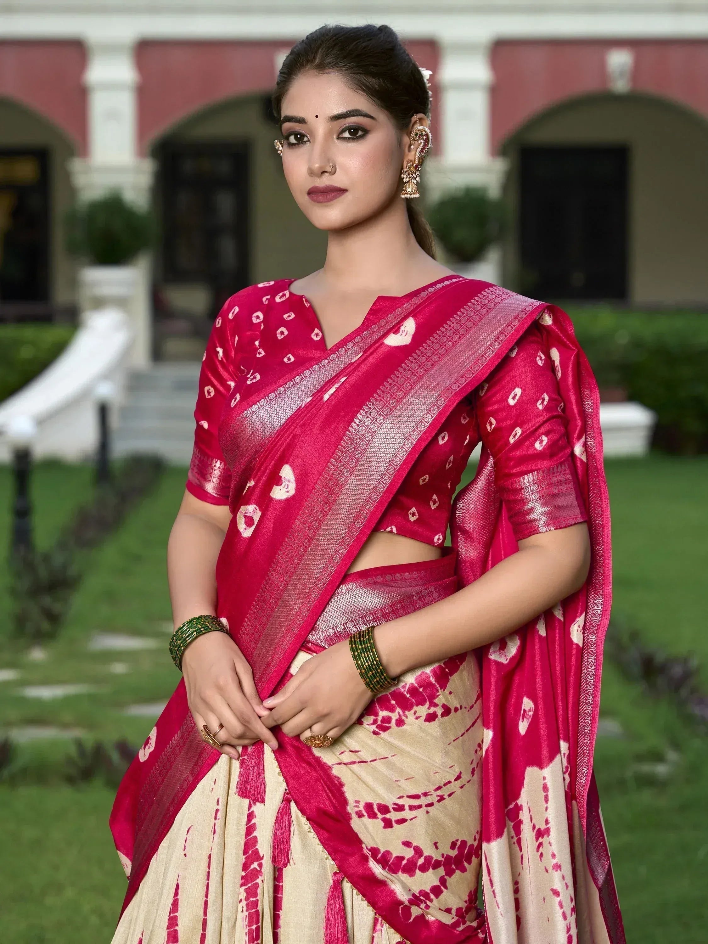 Woman in vibrant pink and cream ethnic saree with gold border, perfect for Indian occasions