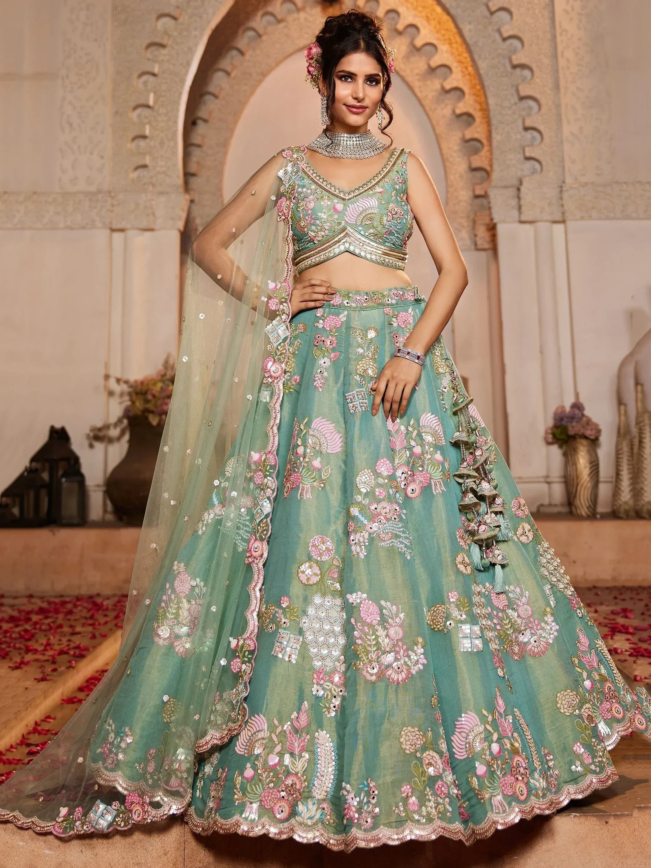 Mint green designer lehenga choli with pink floral embroidery and sheer dupatta, perfect for Indian weddings.