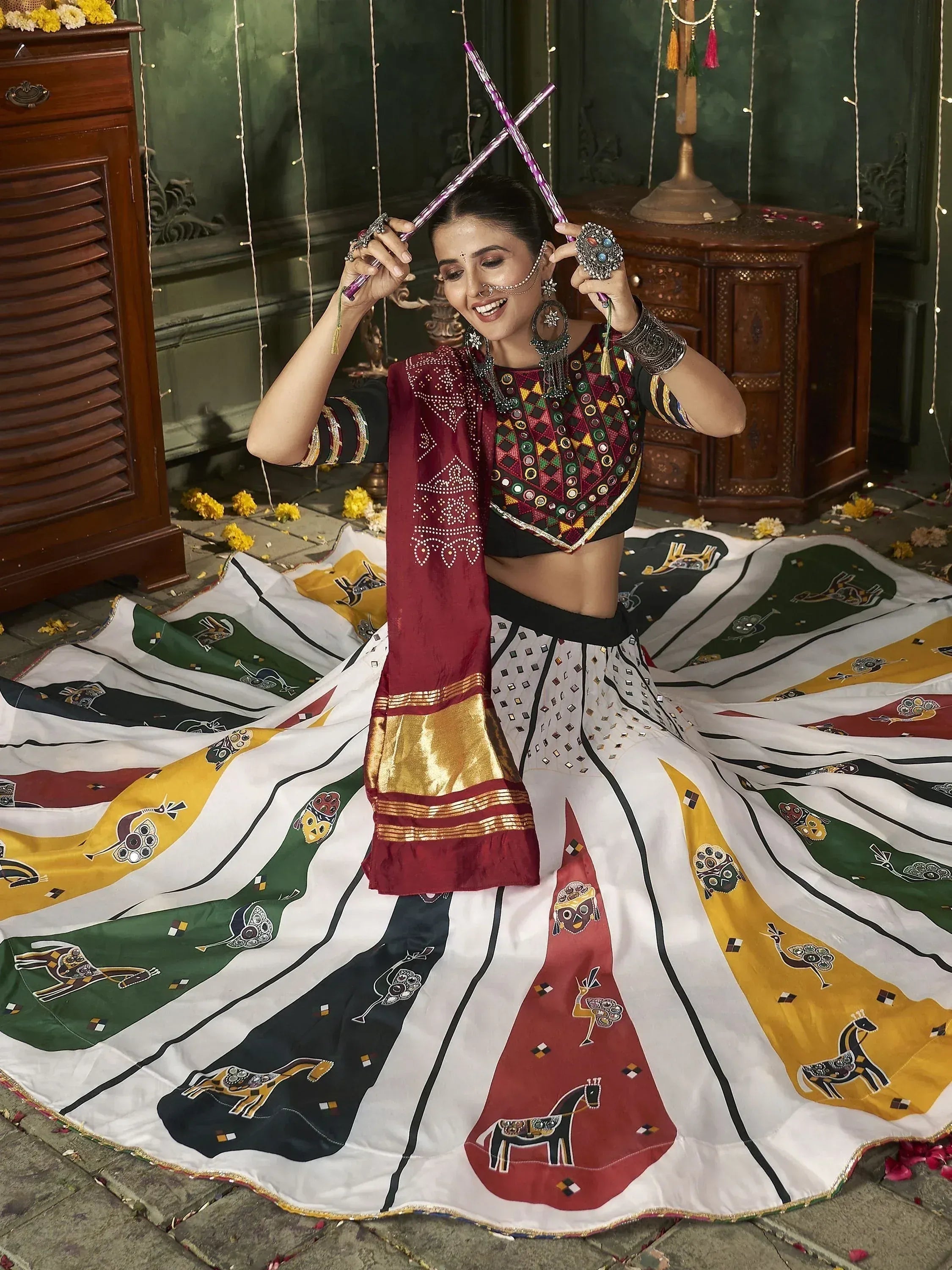 Woman in colorful ethnic lehenga choli with mirror work, dancing with dandiya sticks, festive Indian wear