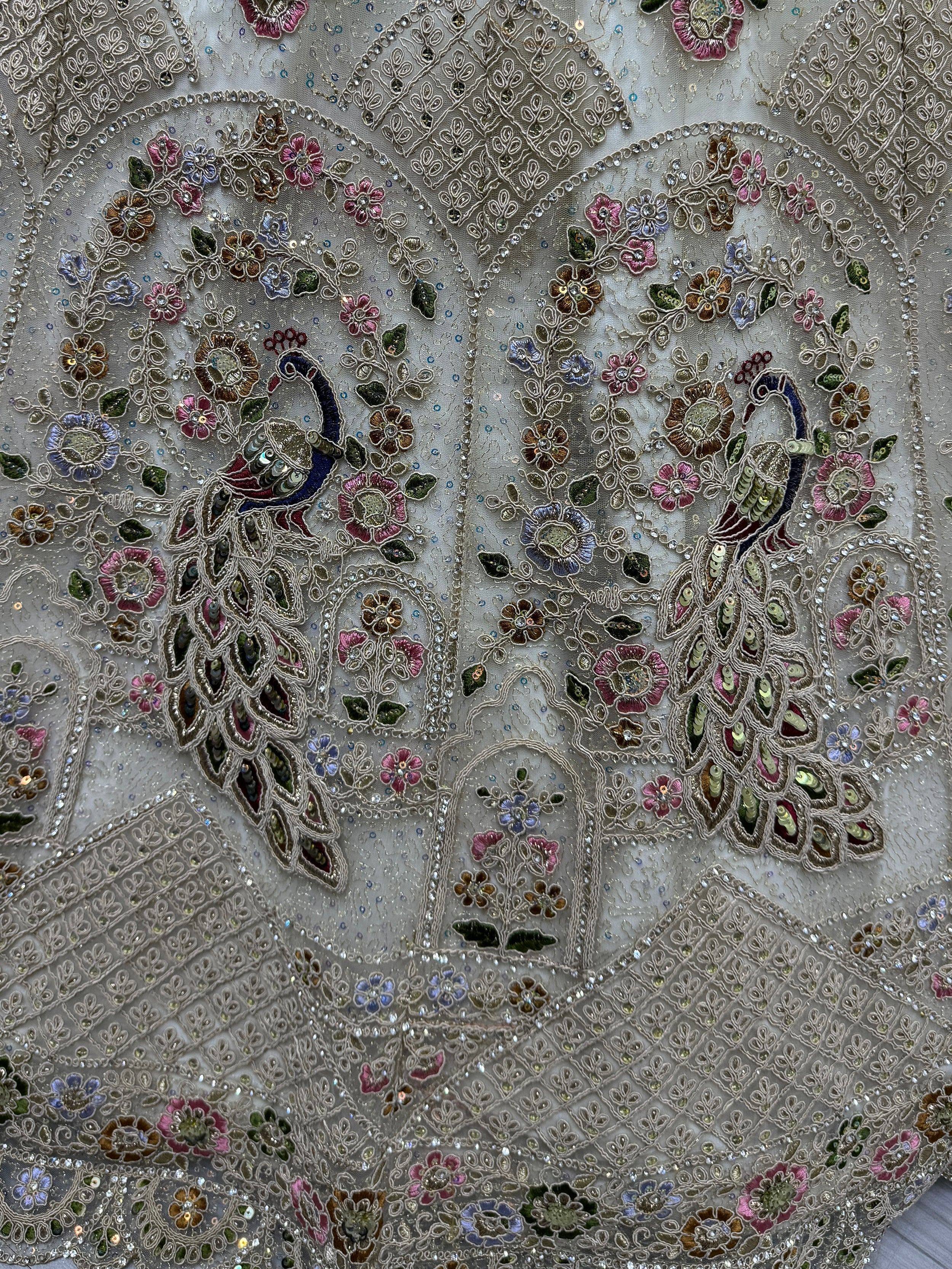 Exquisite peacock and floral embroidery on sheer fabric, perfect for designer lehenga choli or ethnic gown.