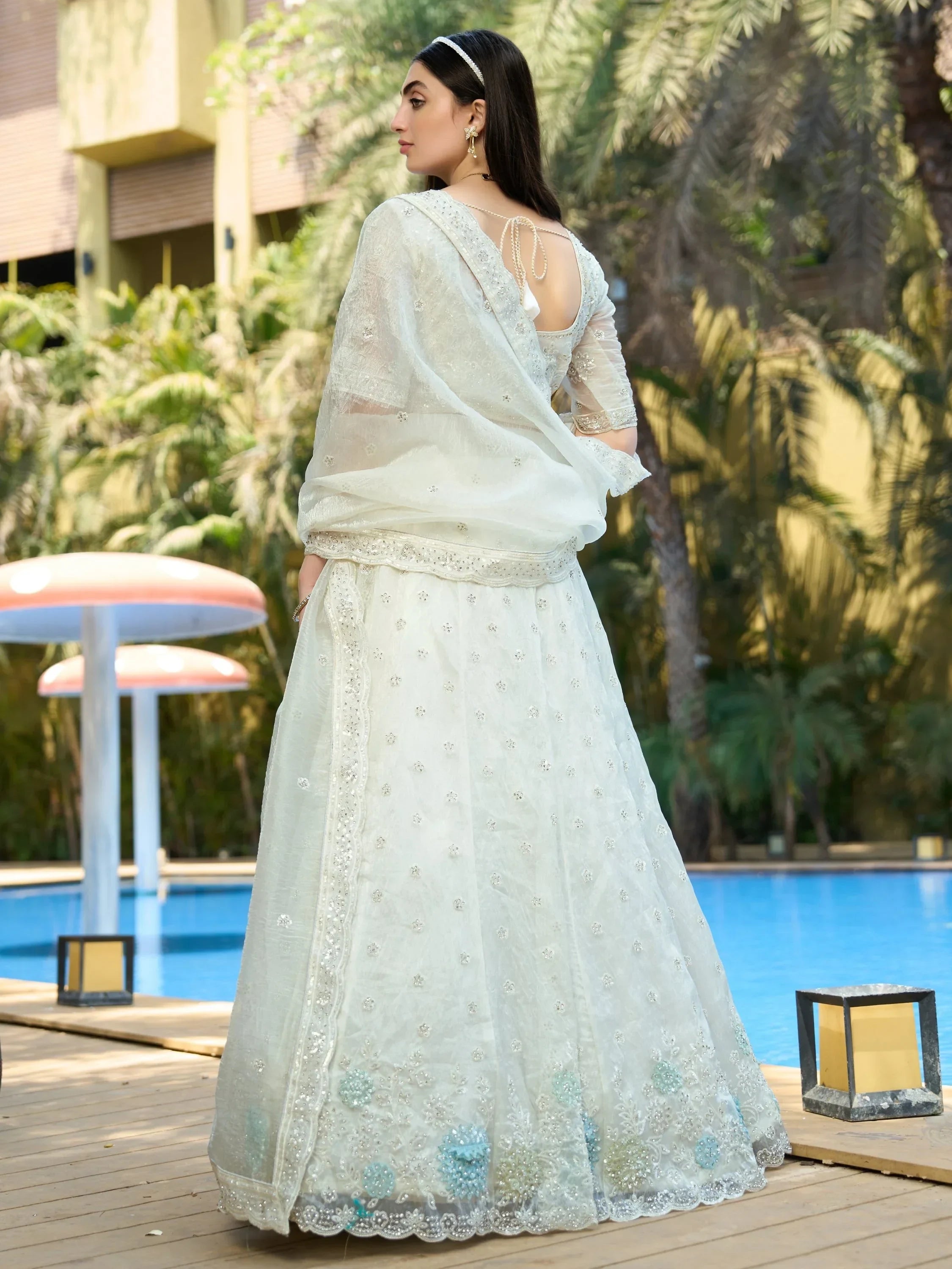 Elegant white embroidered lehenga choli with sheer dupatta, perfect for weddings or festive occasions
