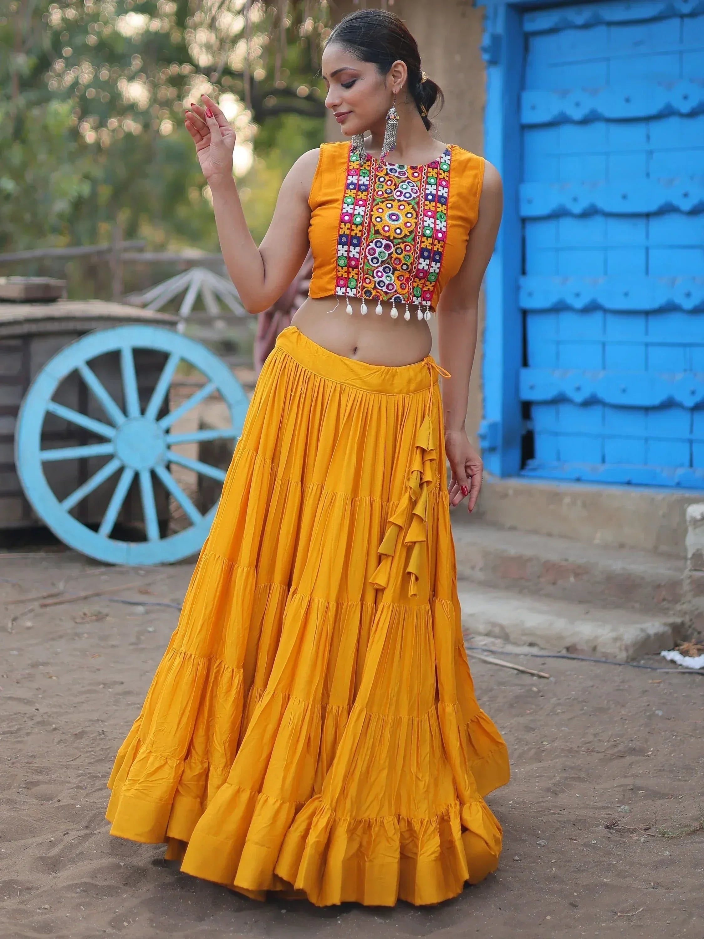 Yellow ethnic crop top with mirror work and tiered skirt, perfect for Indian festive wear