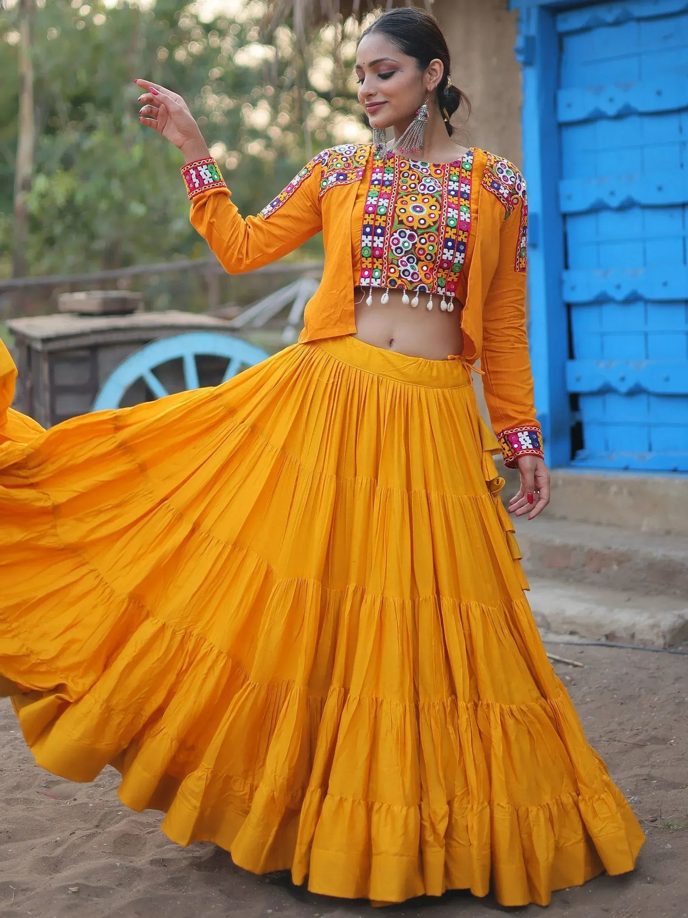 Vibrant yellow ethnic lehenga choli with colorful mirror embroidery, perfect for festive occasions.