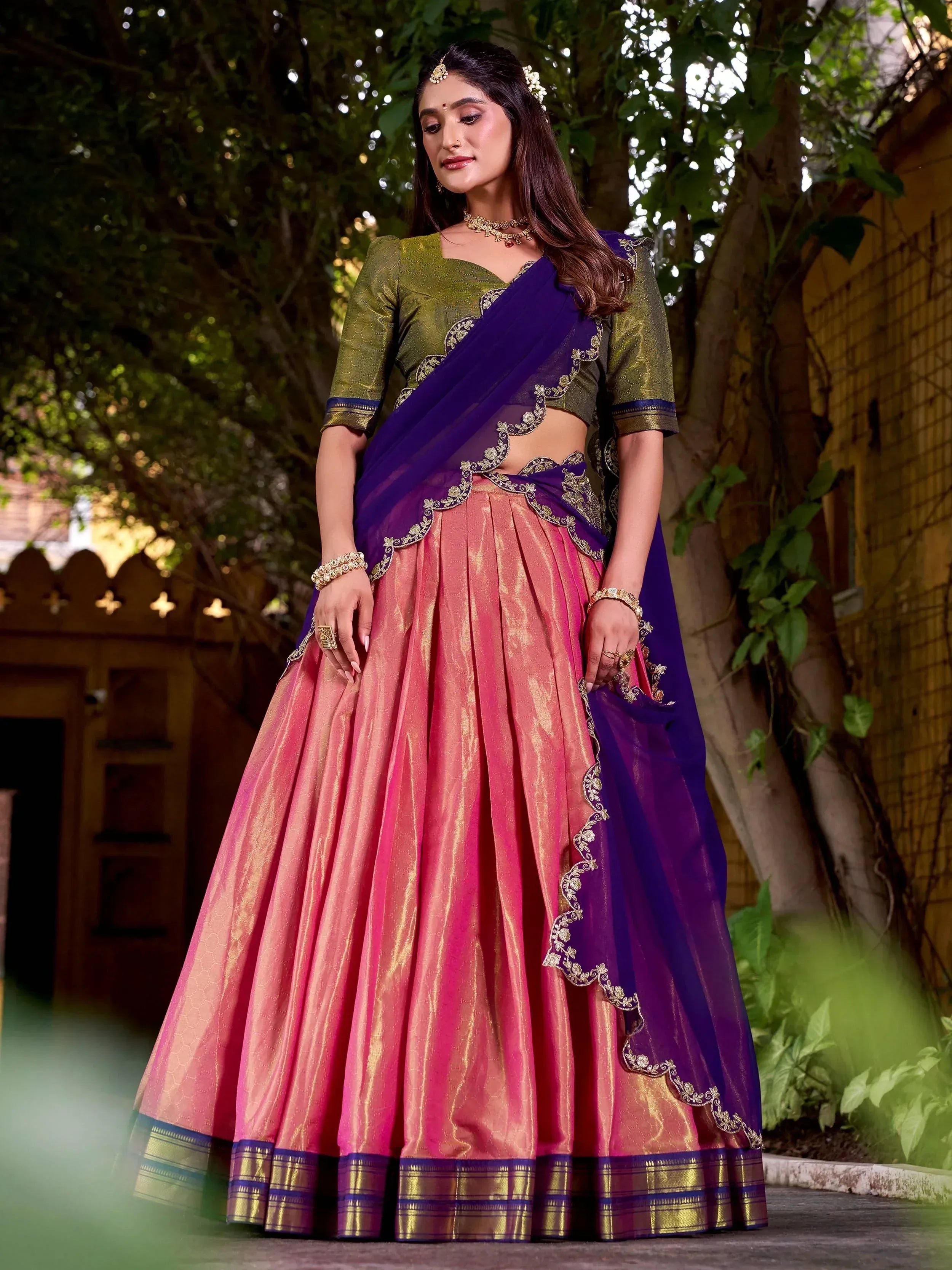Woman in vibrant pink lehenga with purple dupatta and green blouse, Indian ethnic wear