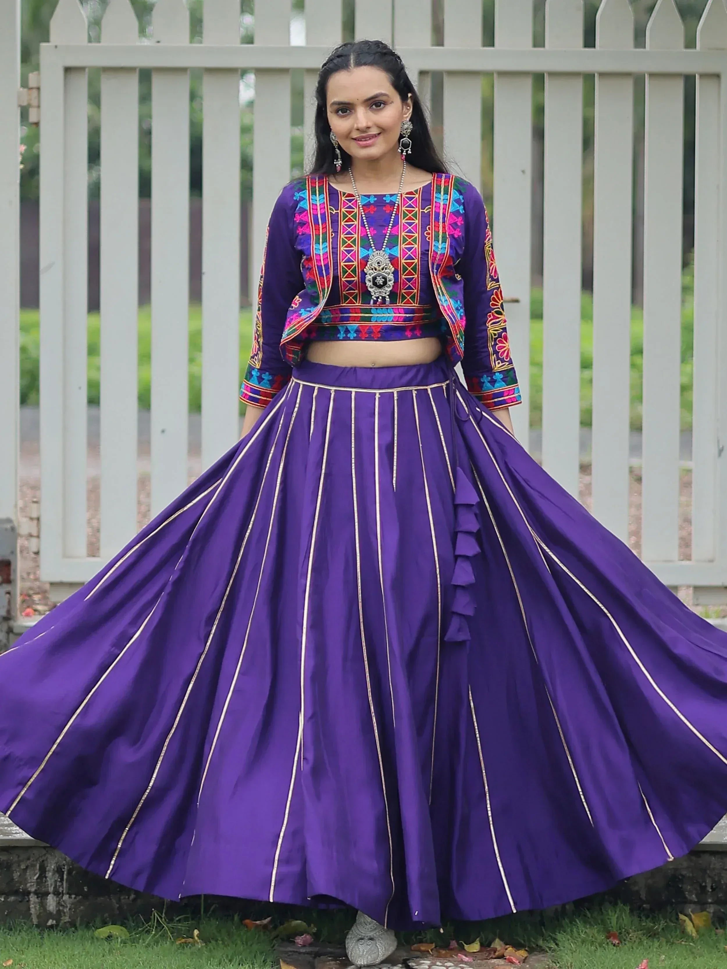 Purple embroidered lehenga choli with gold trim, floral patterns, and ruffled skirt for Indian ethnic wear