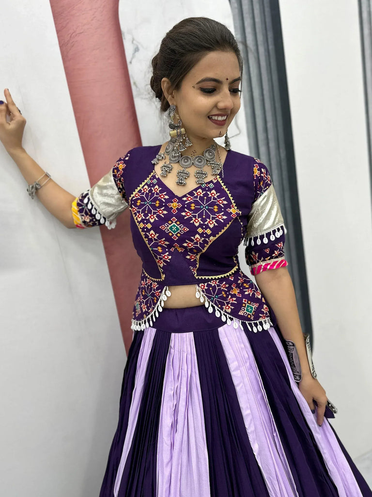 Purple embroidered lehenga choli with mirror work, pleated skirt, and silver jewelry for Indian ethnic wear