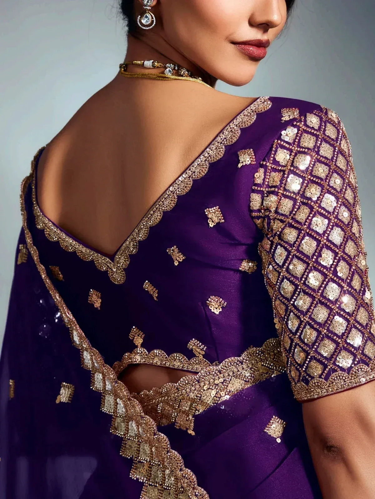 Purple designer saree with gold sequin embroidery and scalloped neckline, perfect for ethnic occasions.