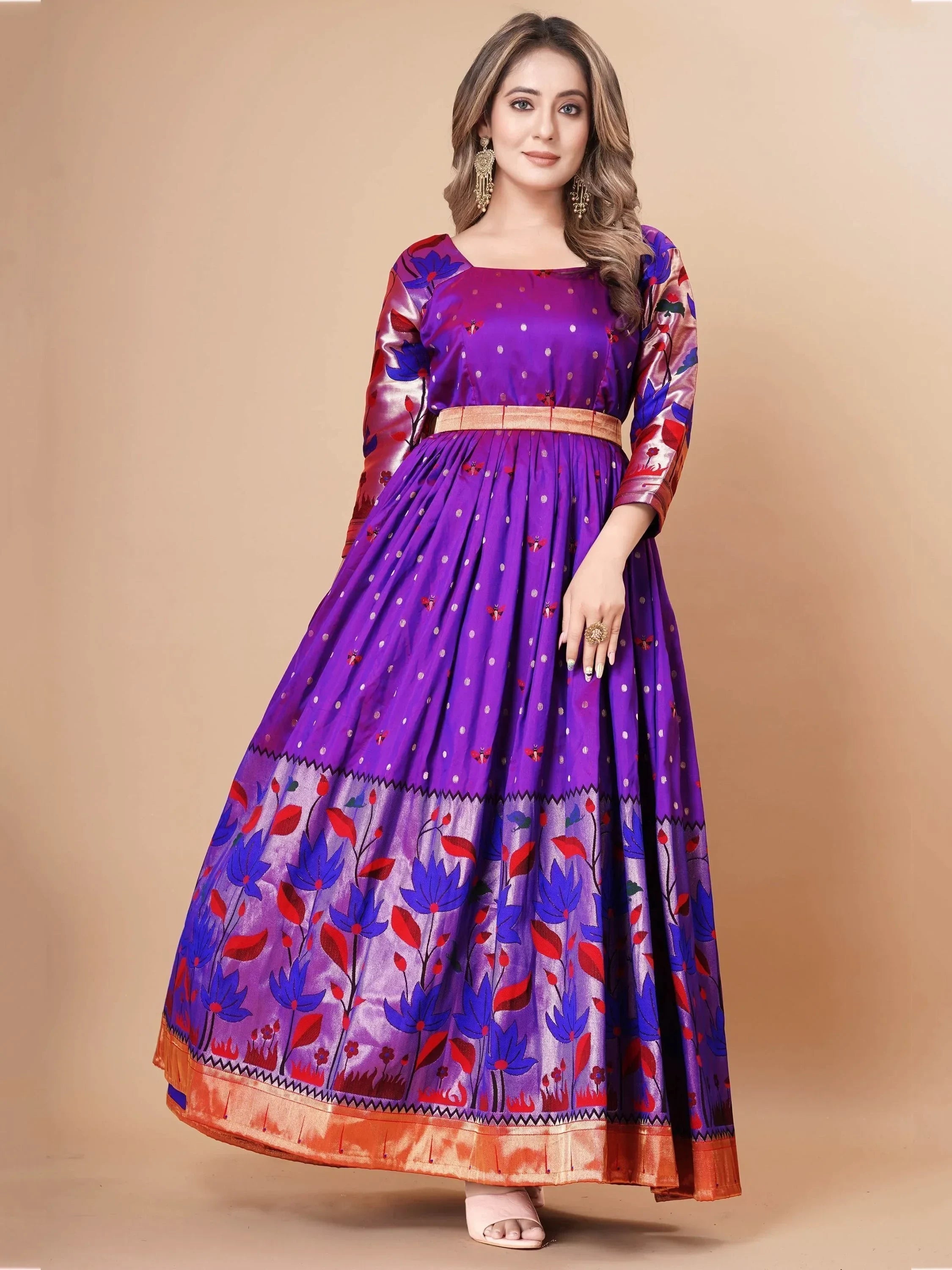 Woman wearing a purple ethnic gown with floral print and gold accents