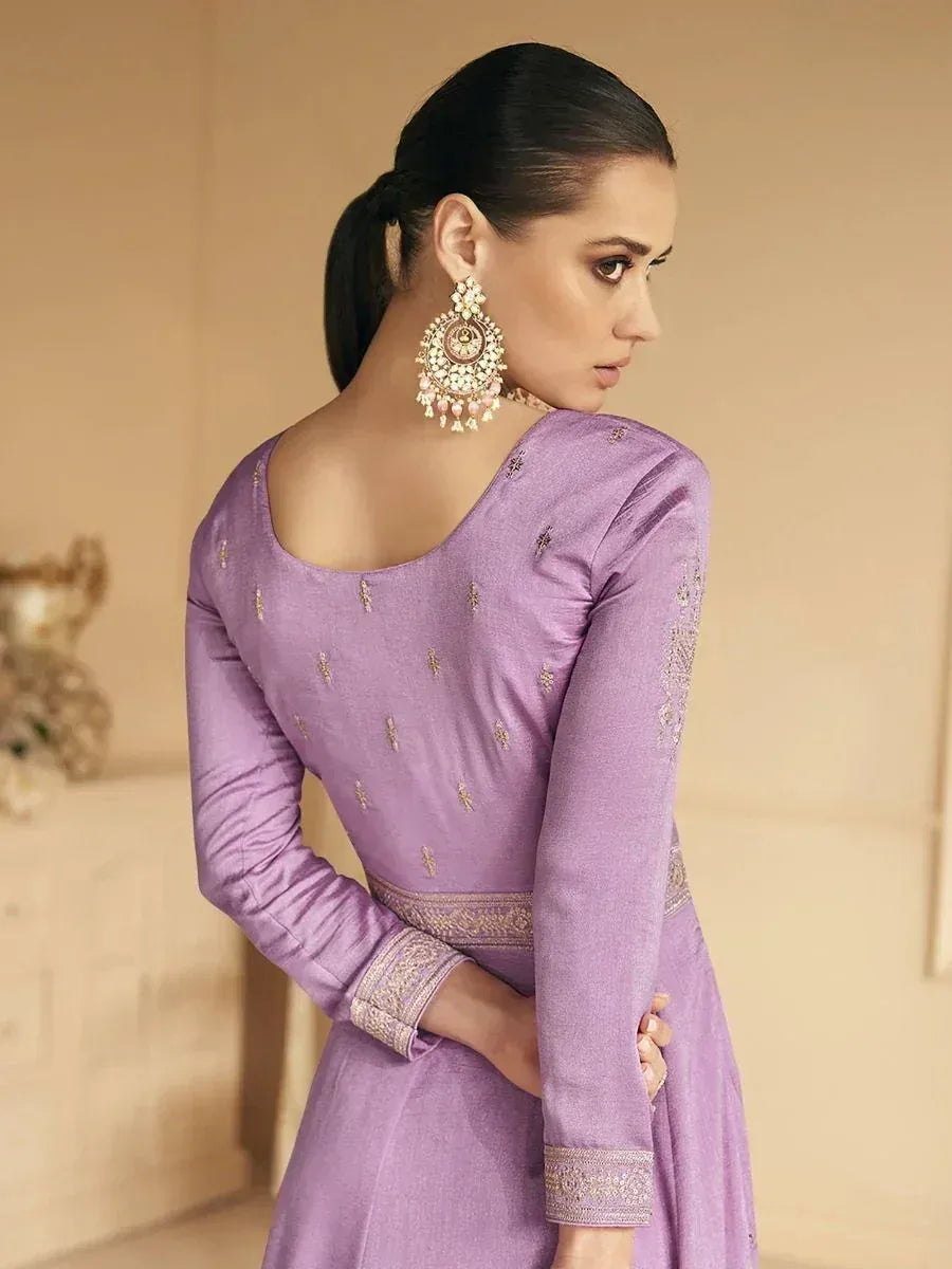 Purple designer ethnic gown with gold embroidery and back neckline, paired with traditional jhumka earrings