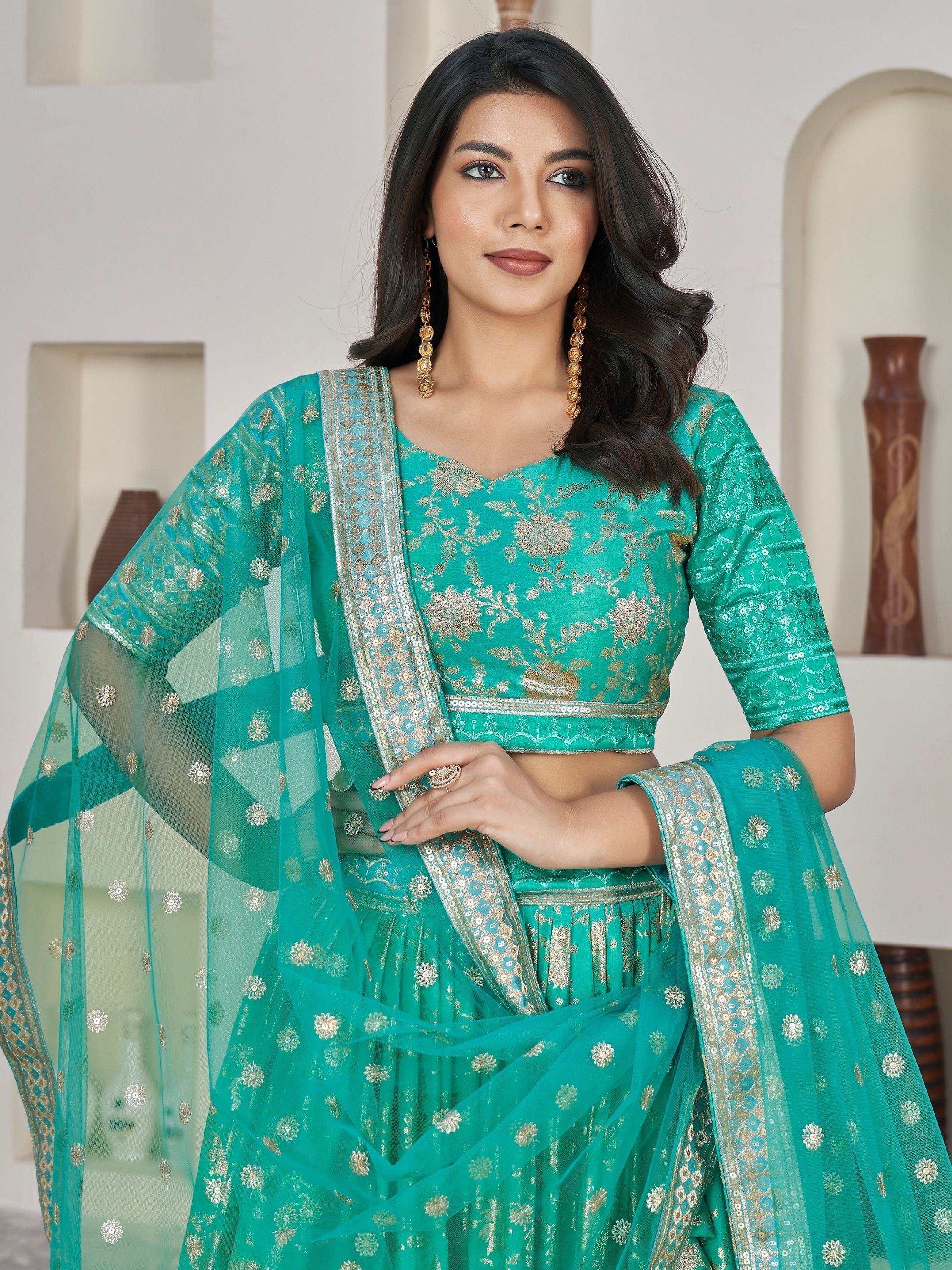 Teal green embroidered lehenga choli with gold floral work and sheer dupatta, perfect for Indian ethnic wear occasions.