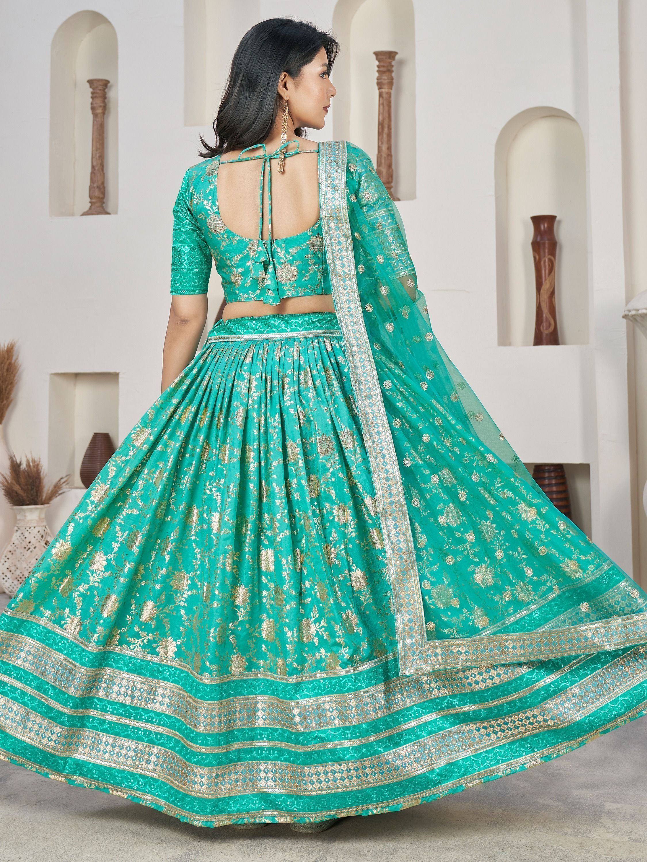 Teal green designer lehenga choli with gold floral embroidery and sheer dupatta, perfect for Indian ethnic occasions