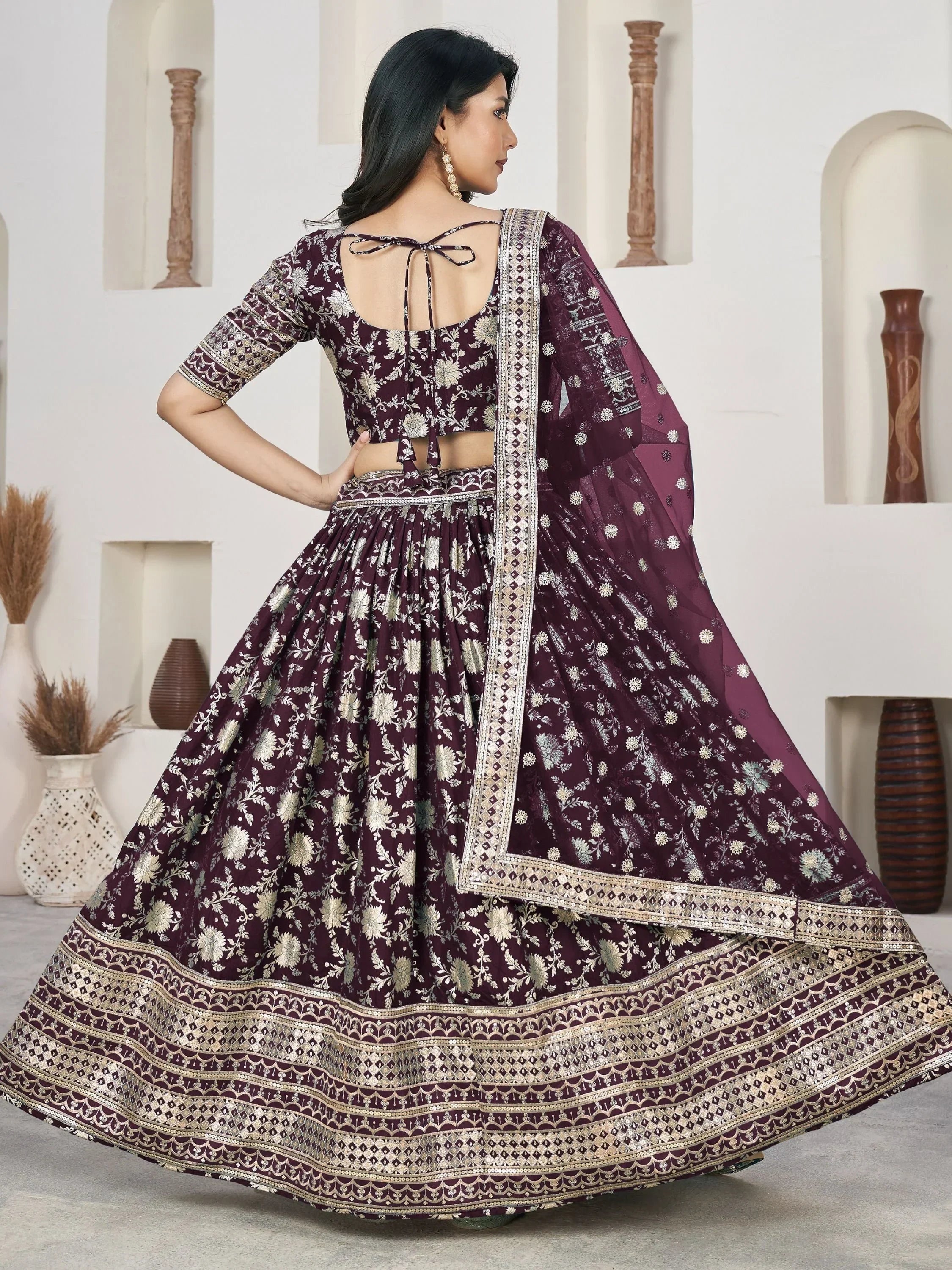 Elegant maroon lehenga choli with gold floral embroidery and sequin border, perfect for Indian ethnic occasions.