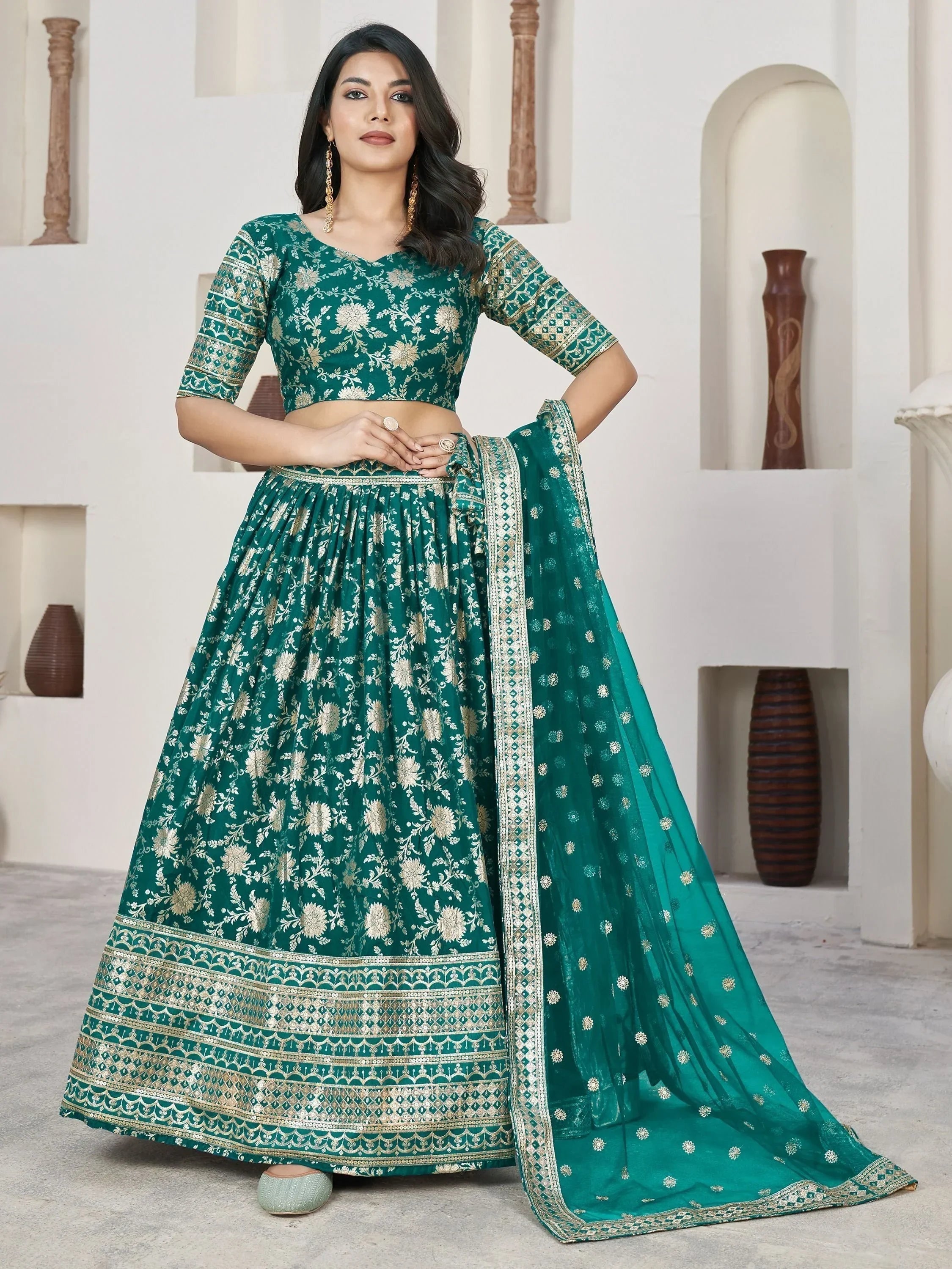 Emerald green designer lehenga choli with gold floral embroidery and matching dupatta, perfect for Indian ethnic occasions.