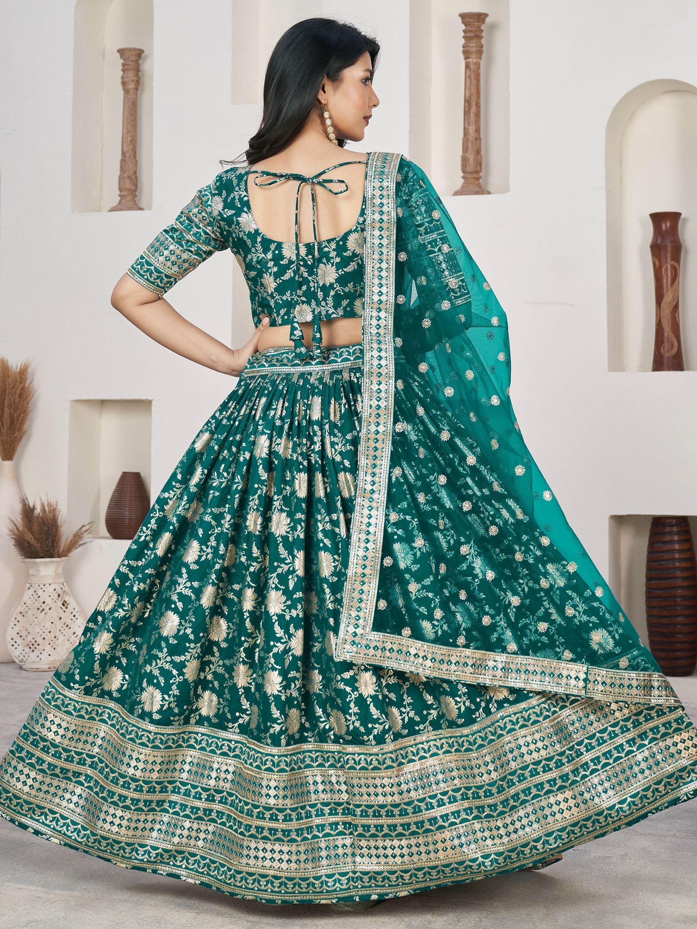 Emerald green designer lehenga choli with gold floral embroidery and back tie blouse, perfect for Indian weddings.